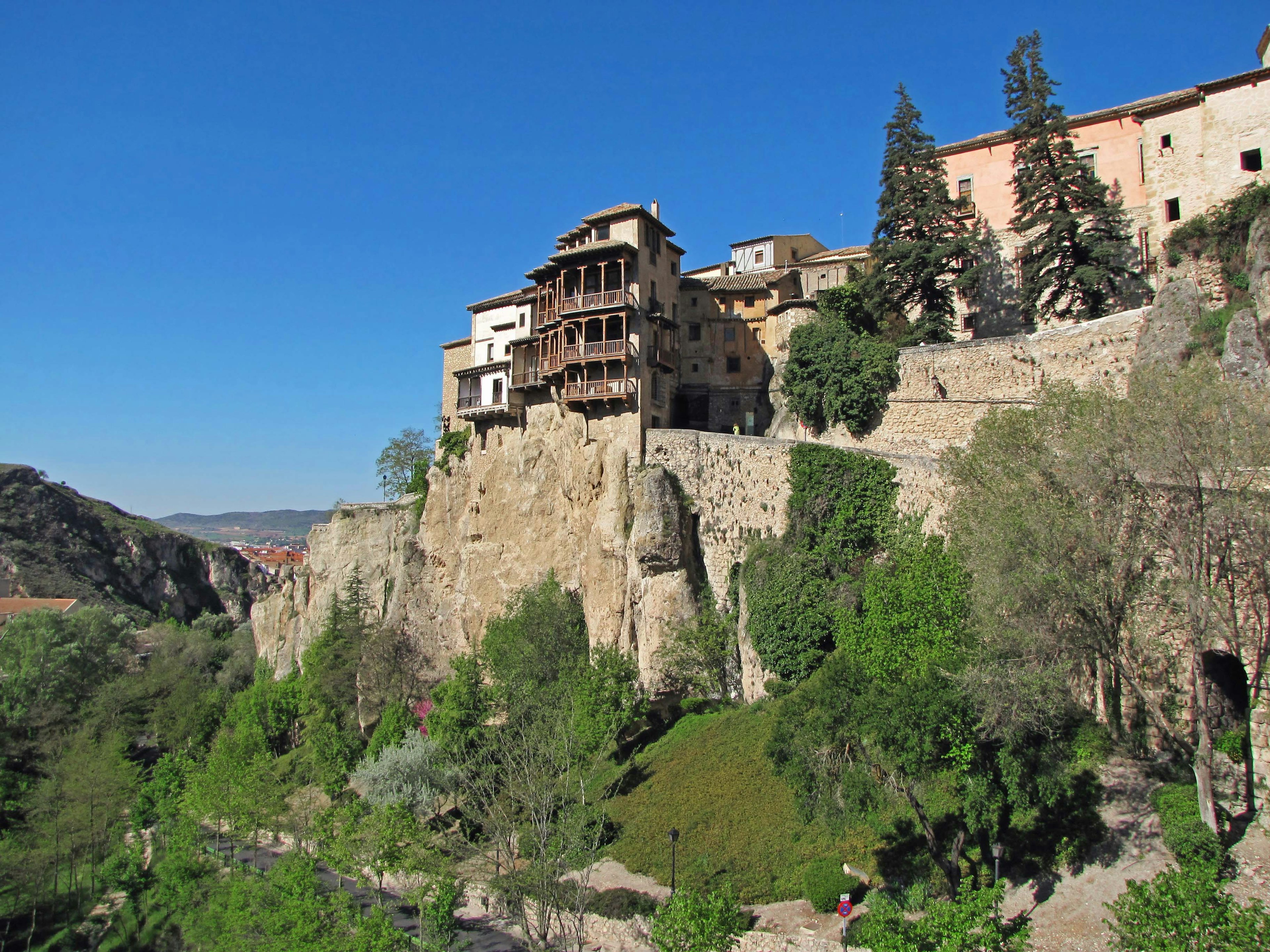 Historic houses perched on a high cliff with lush greenery