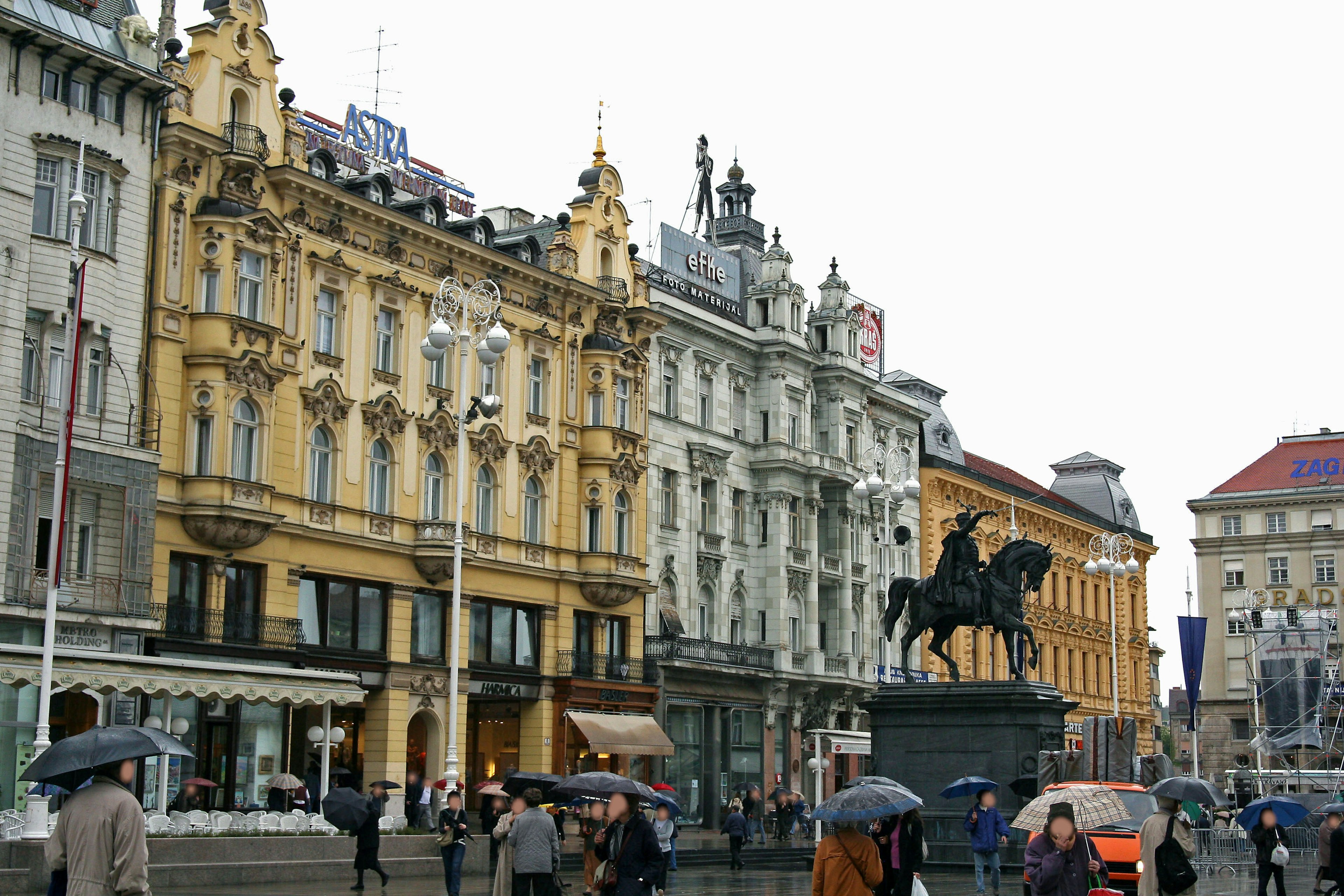 Edificios históricos y estatua ecuestre en Zagreb en un día lluvioso