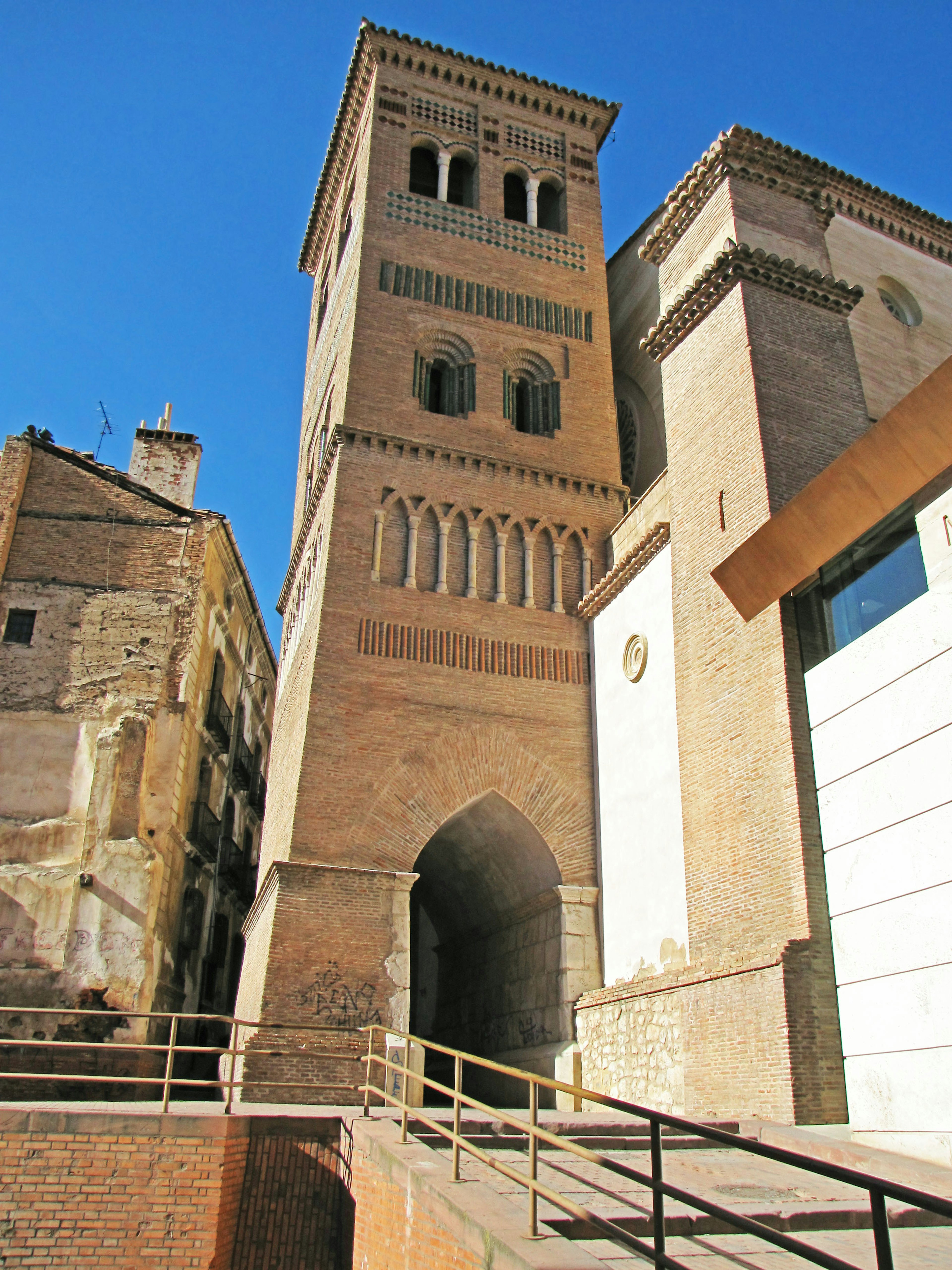 Historischer Ziegelturm neben einem modernen Gebäude