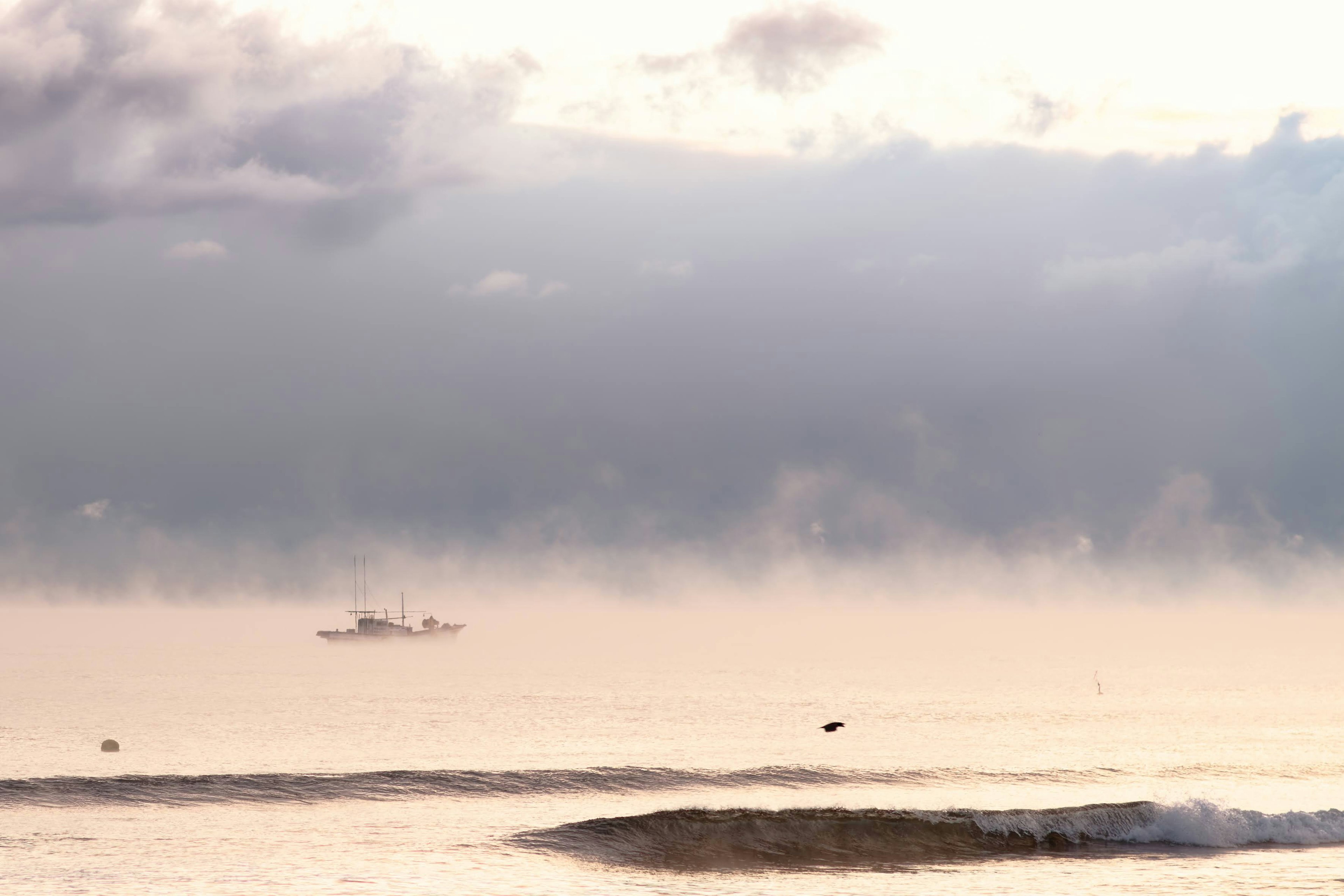 Ein Schiff, das auf einem ruhigen Meer unter einem bewölkten Himmel schwebt