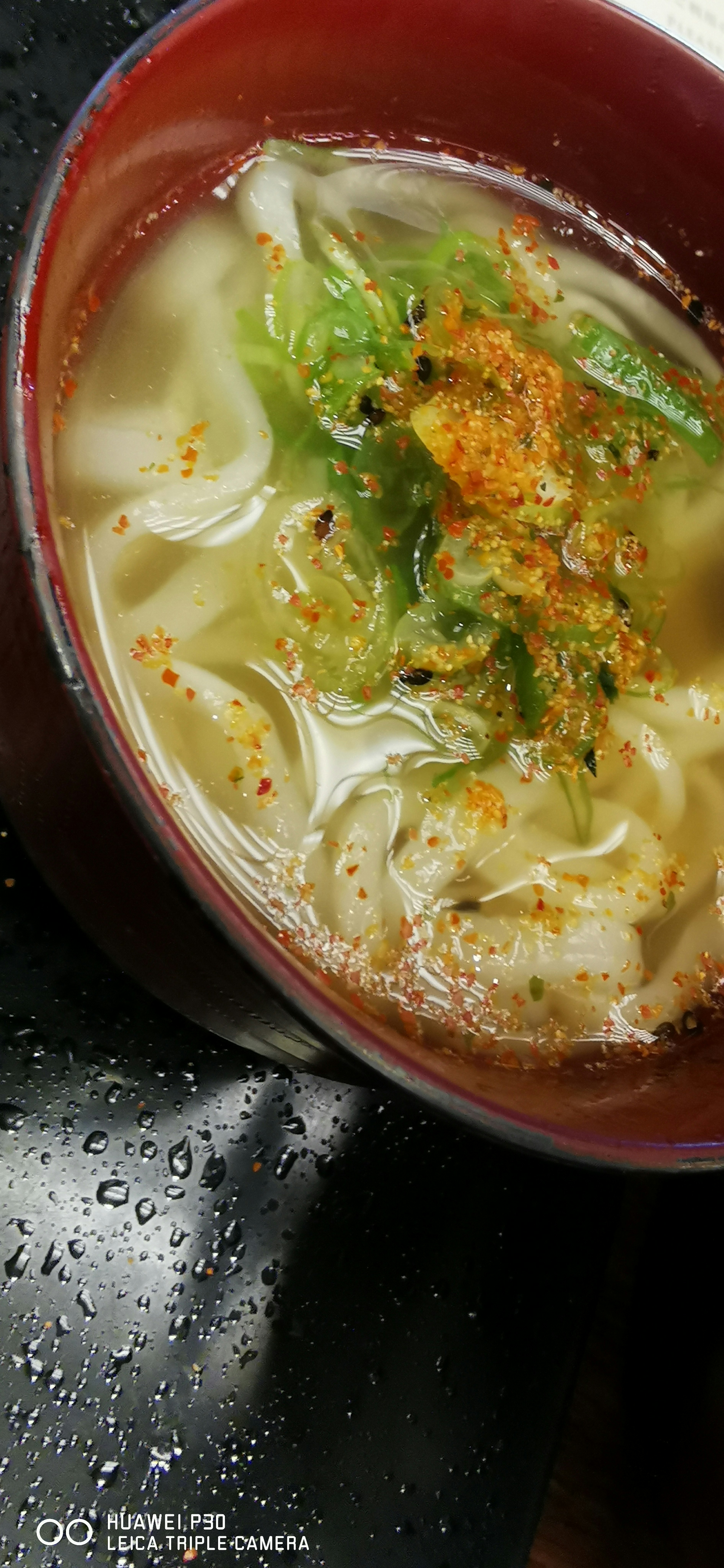 Bowl of noodle soup with green onions and spices