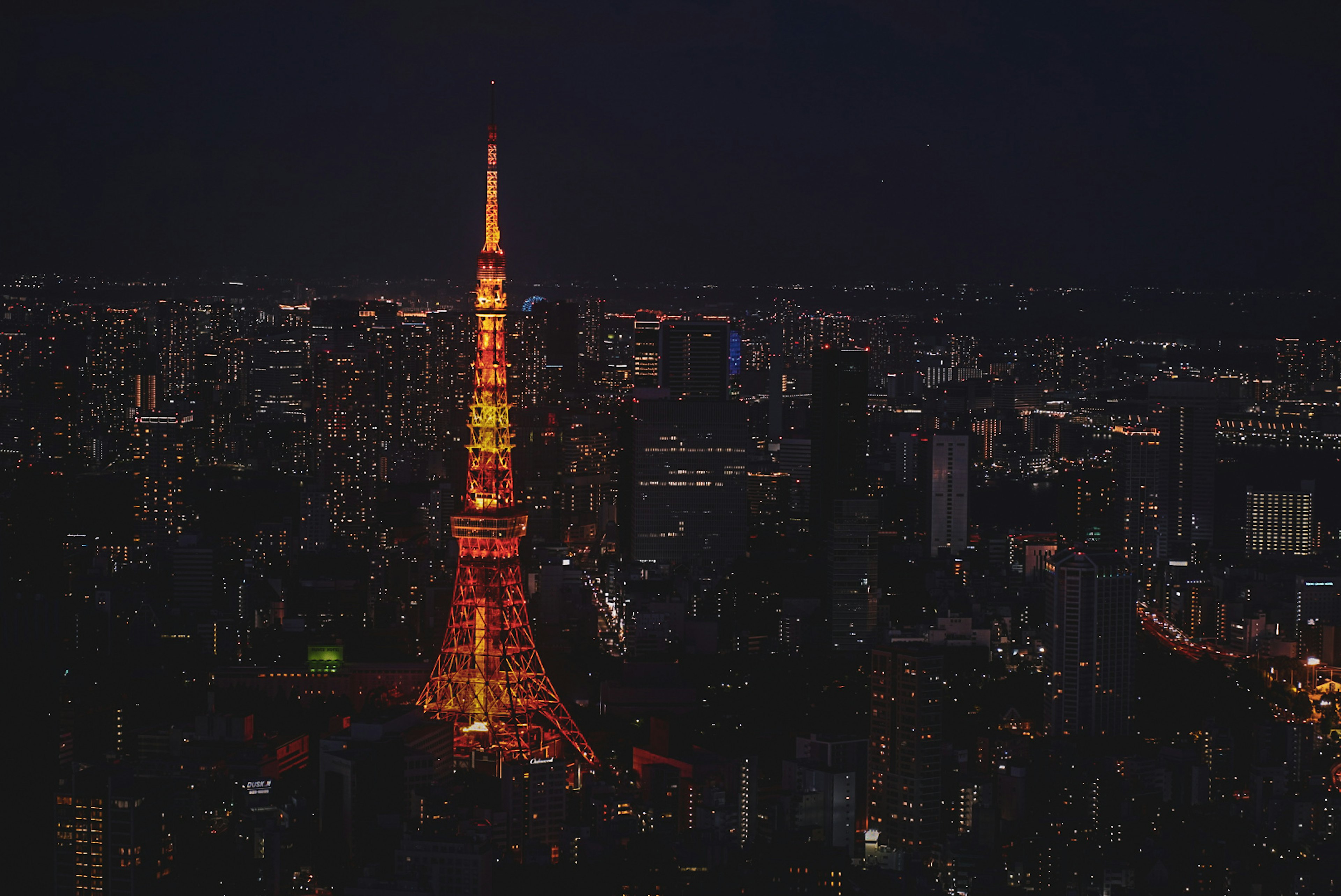 Tokyo Tower nachts beleuchtet mit einer lebhaften Stadtlandschaft