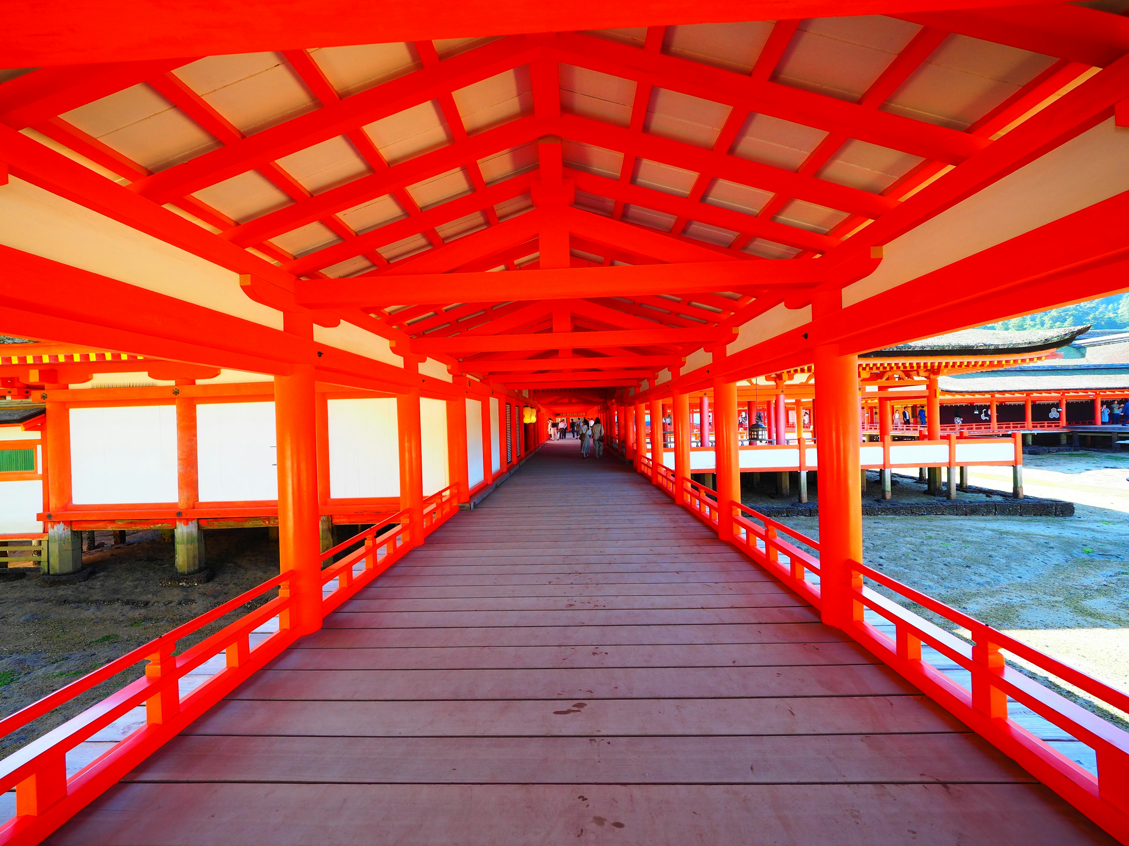 Un chemin vibrant rouge menant à travers une structure japonaise traditionnelle