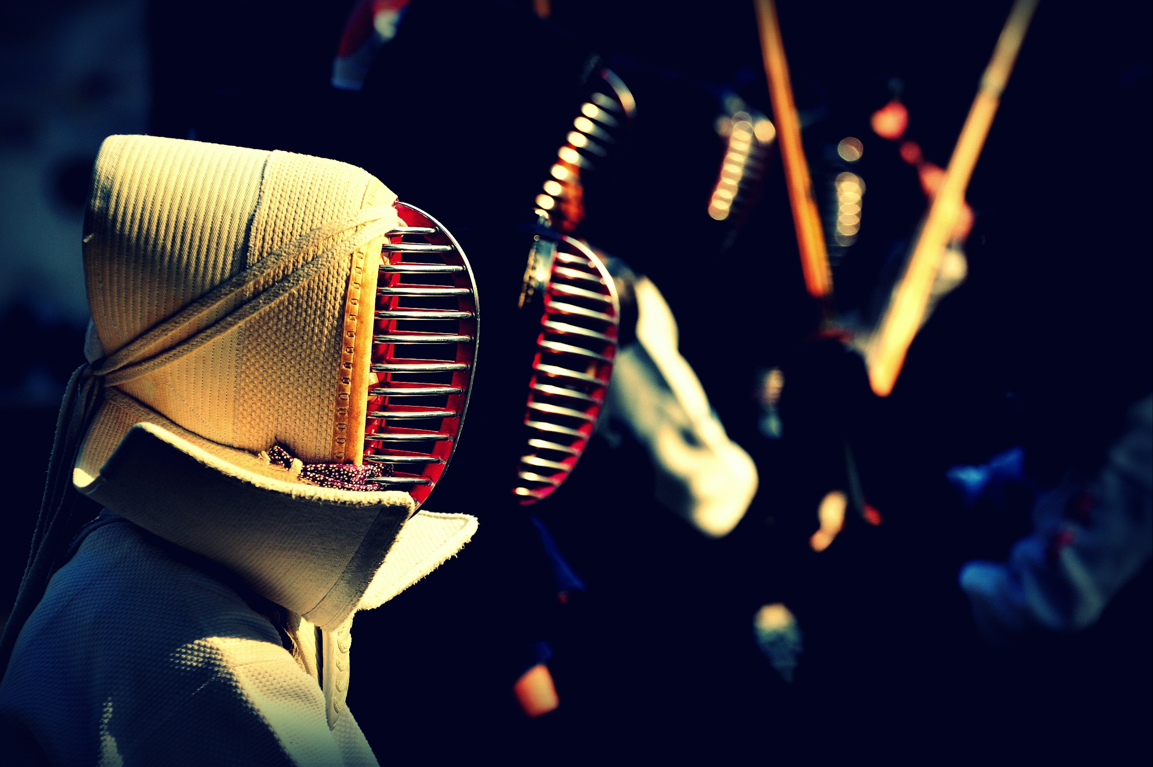 Close-up of kendo players in protective gear during a match