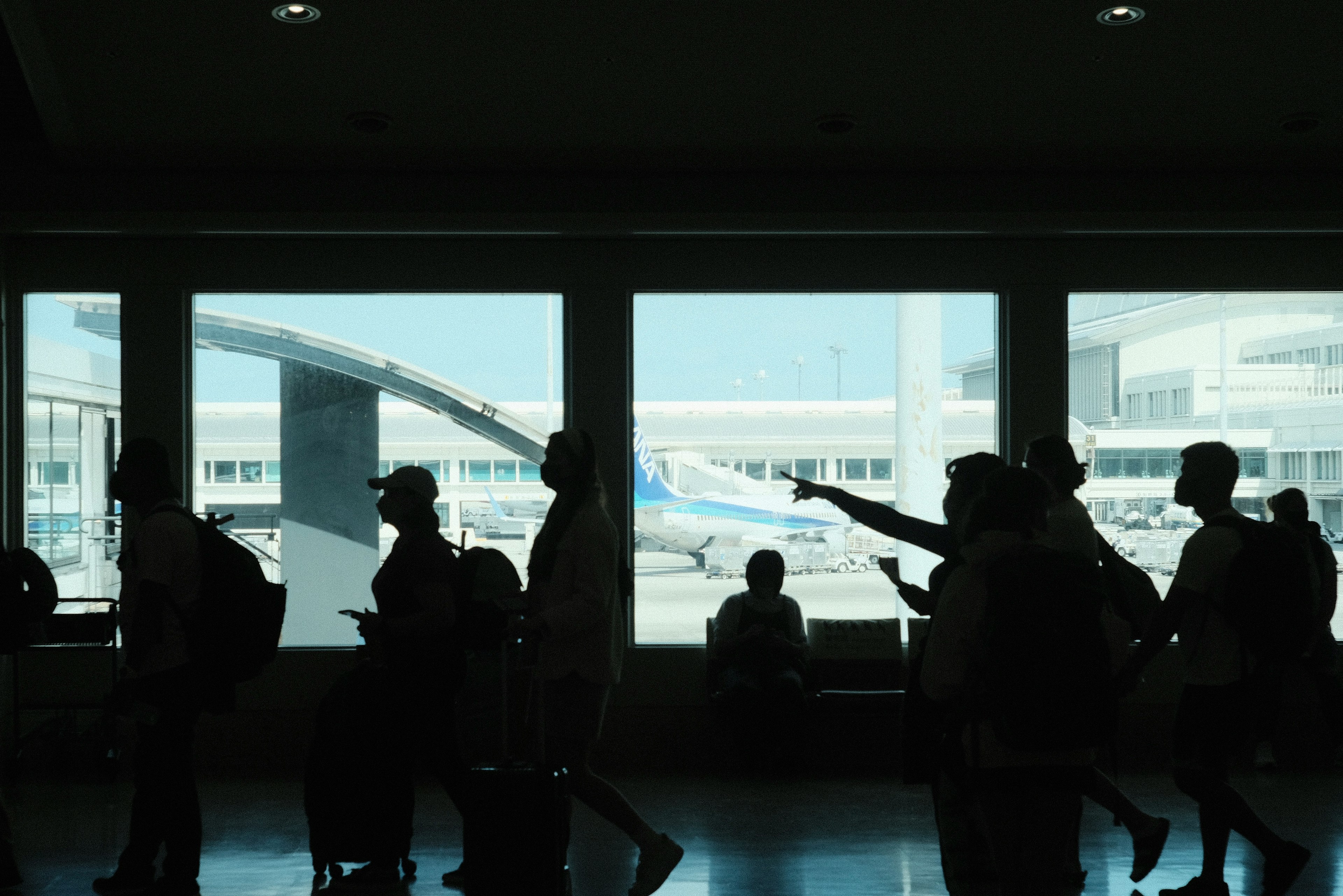 공항 터미널의 사람들 실루엣과 보이는 비행기