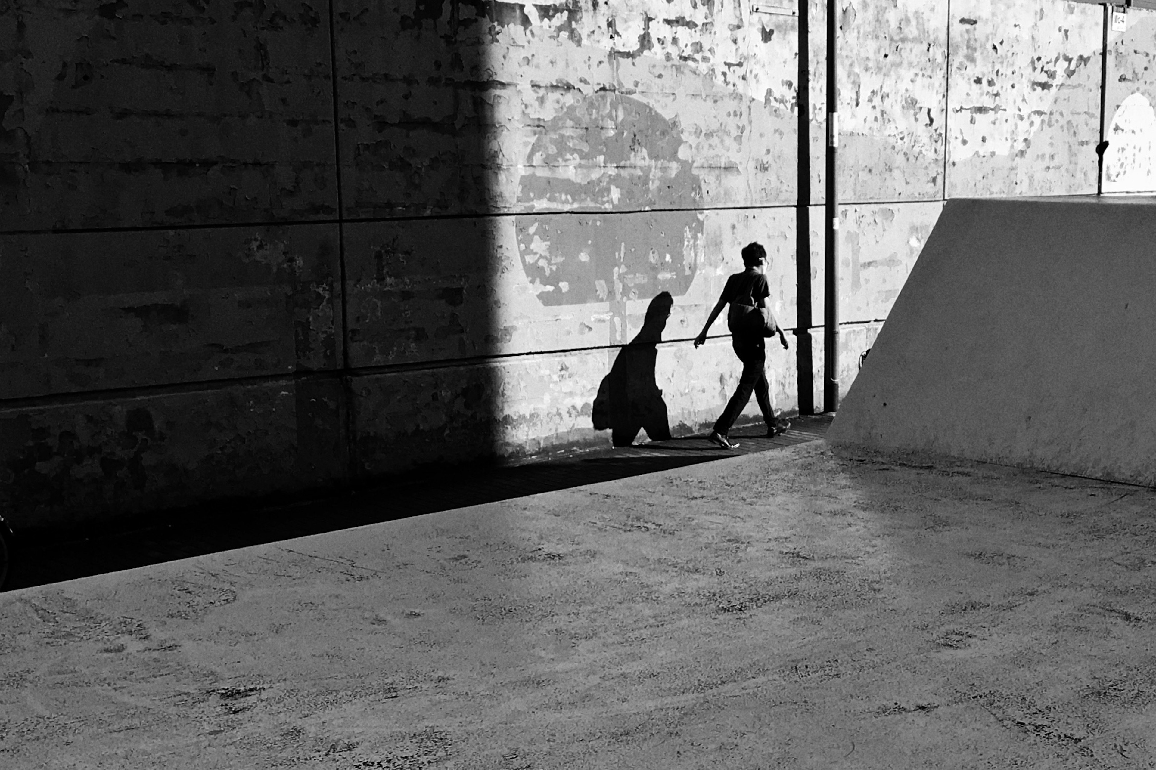 Dos figuras caminando en la sombra con una guitarra