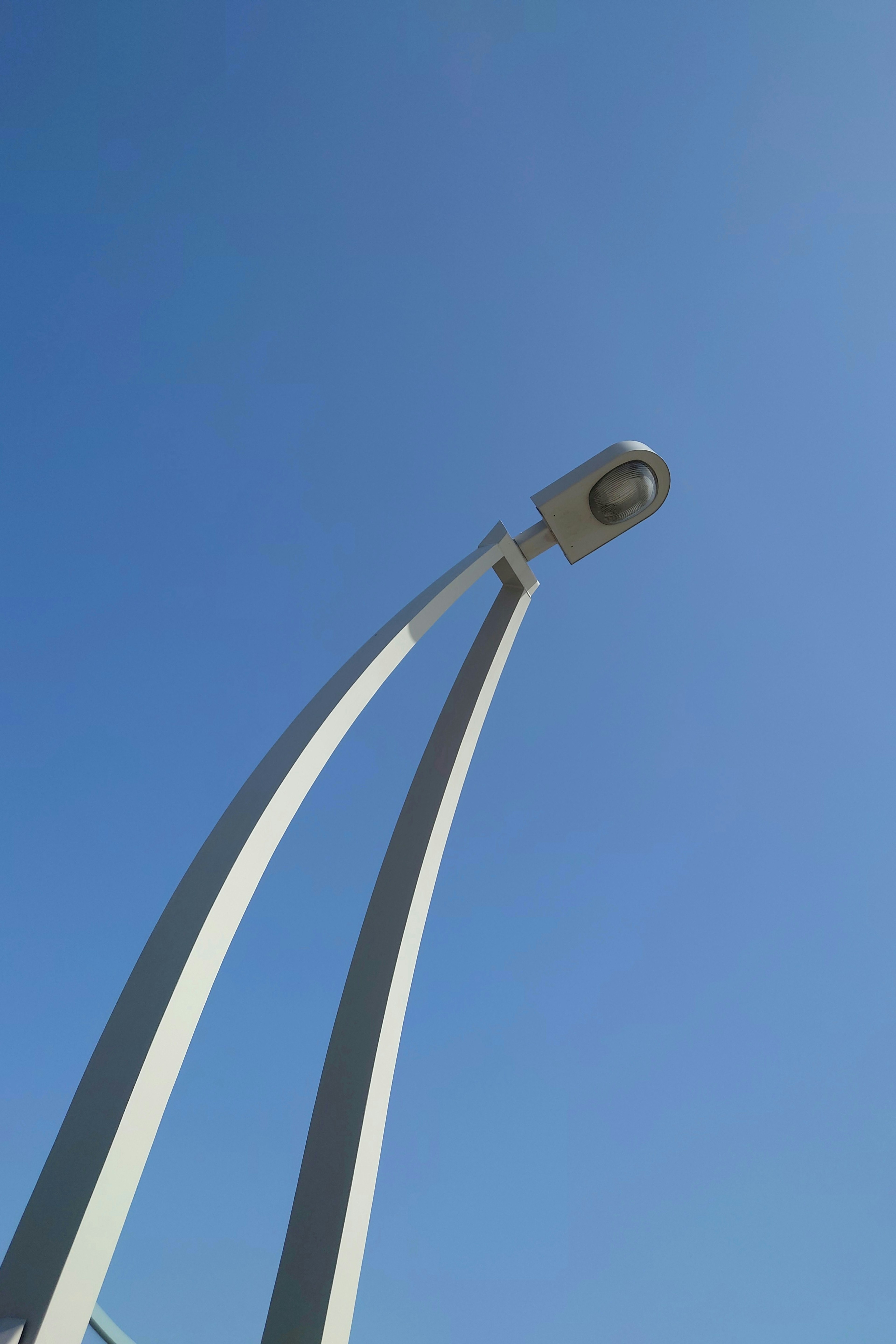 Diseño moderno de farola bajo un cielo azul claro