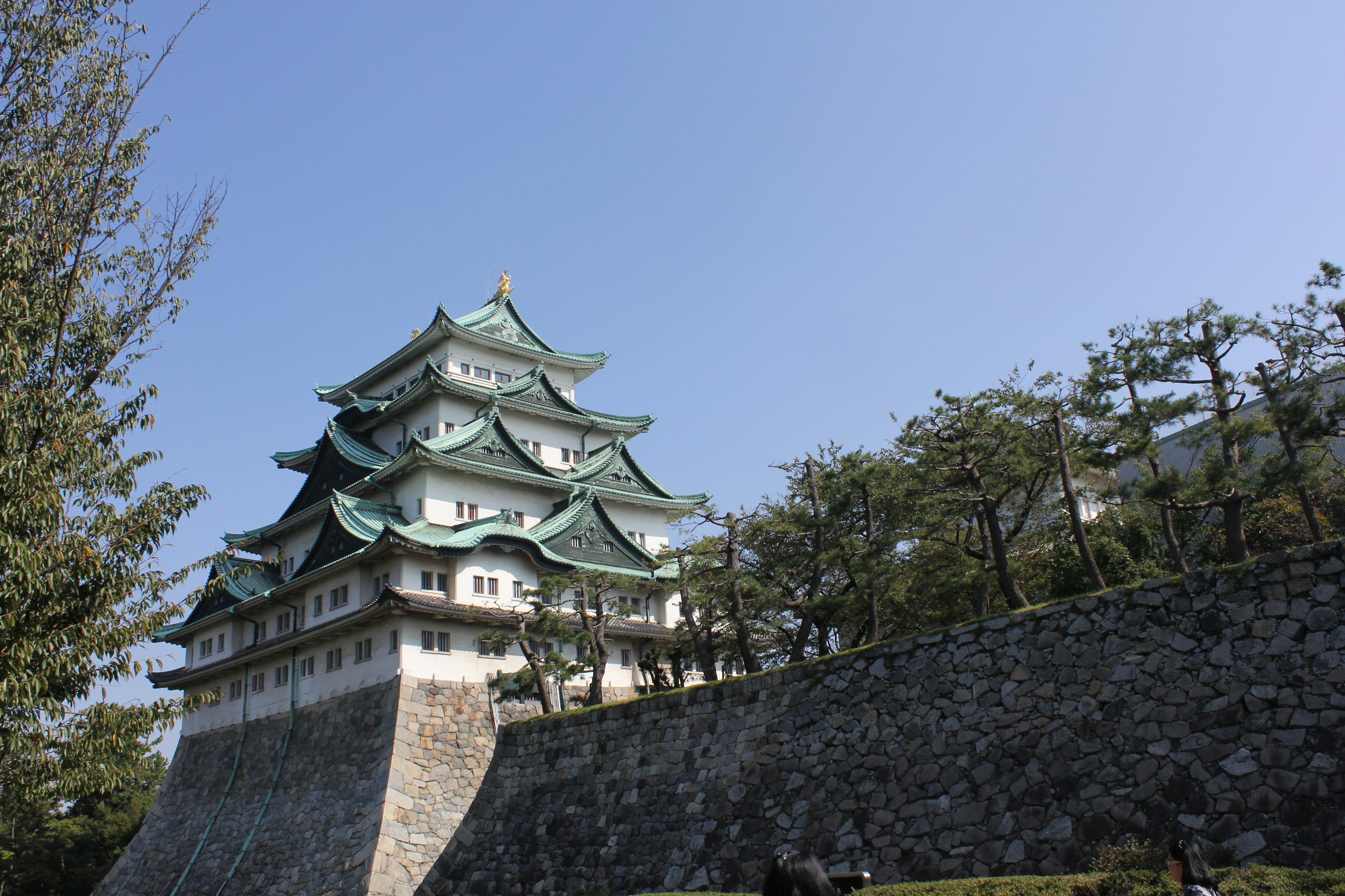 Eksterior indah Kastil Nagoya dengan atap hijau di bawah langit biru