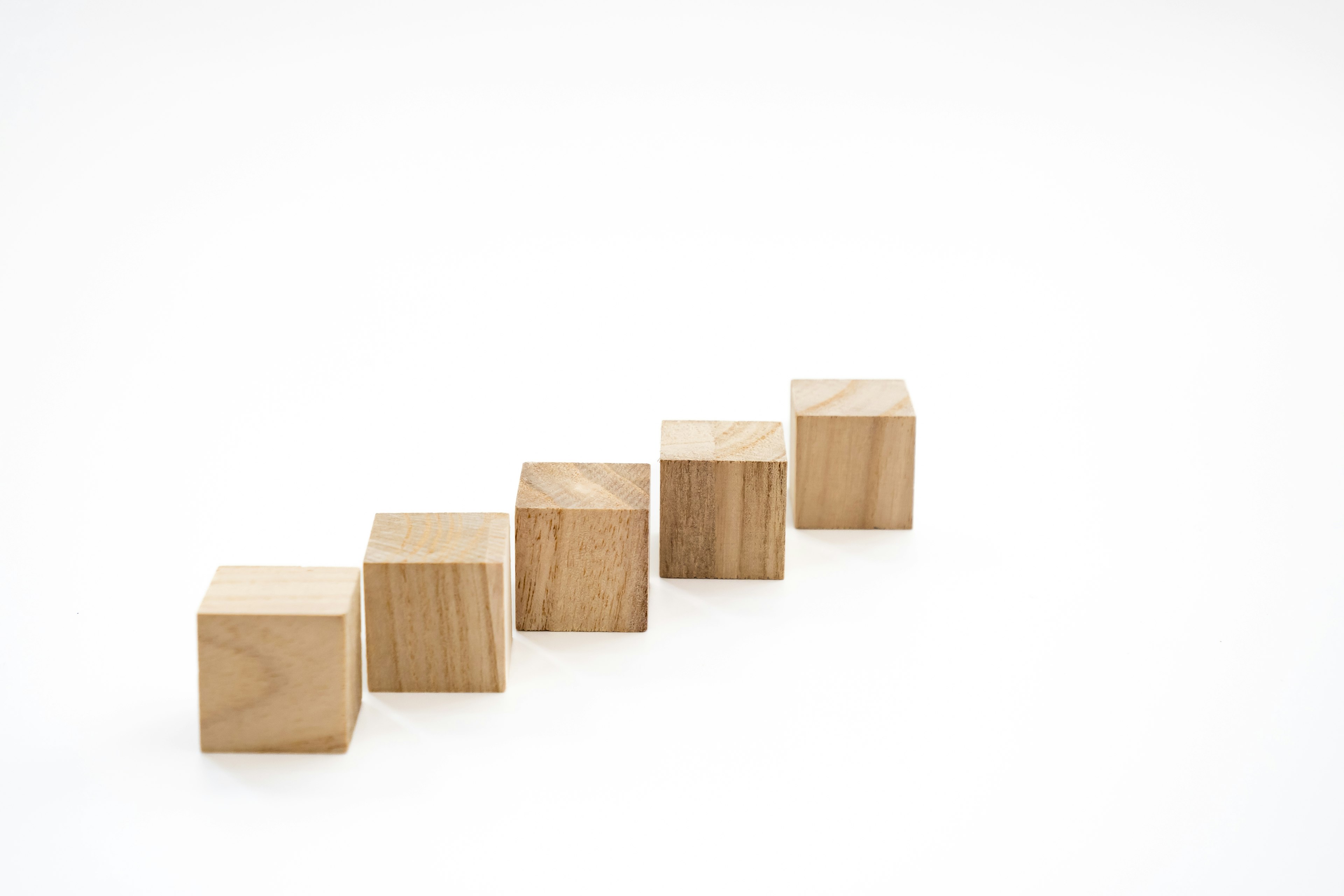 Five wooden cubes arranged in a line on a white background