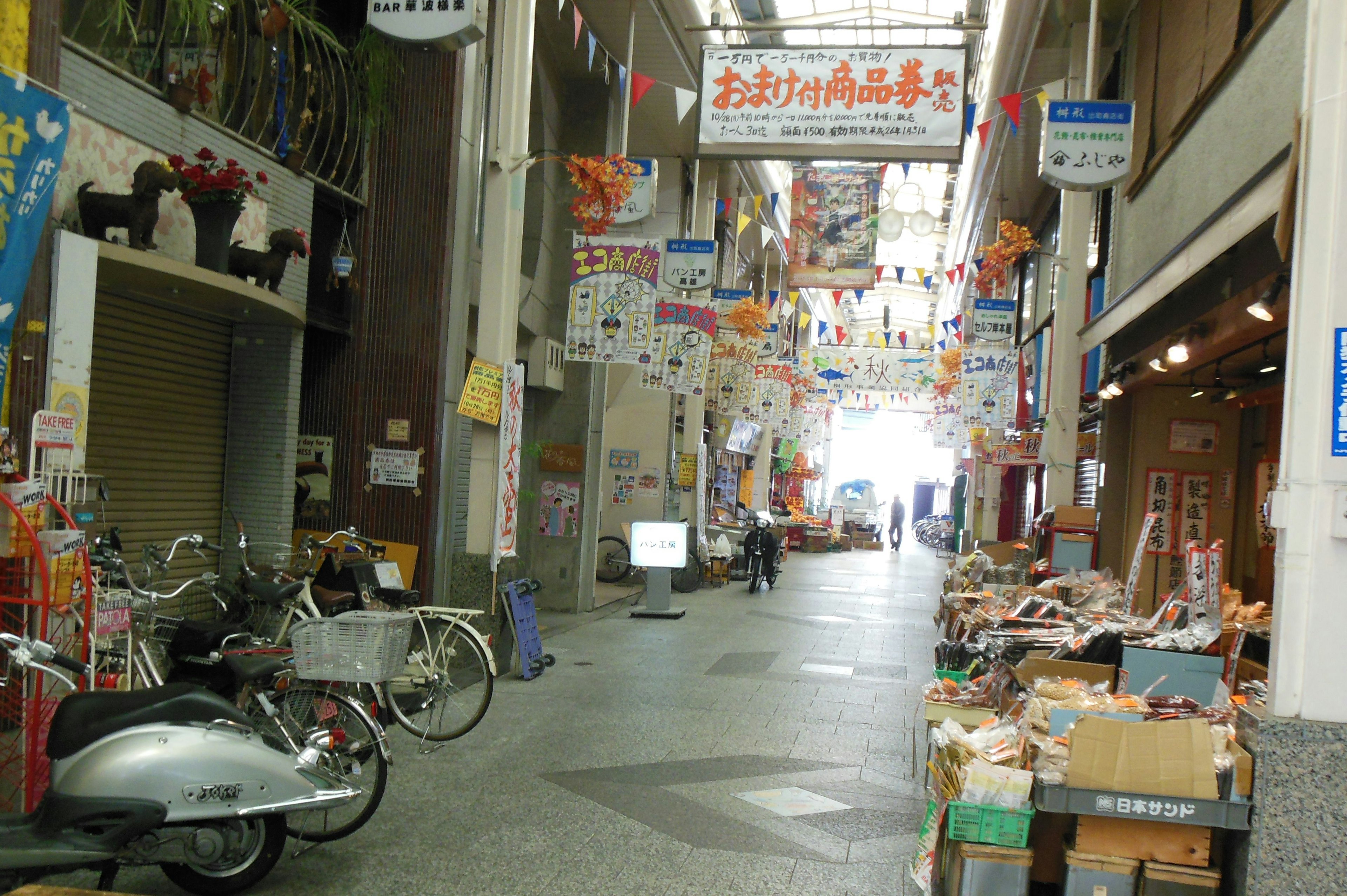 A vibrant shopping street with bicycles and goods displayed