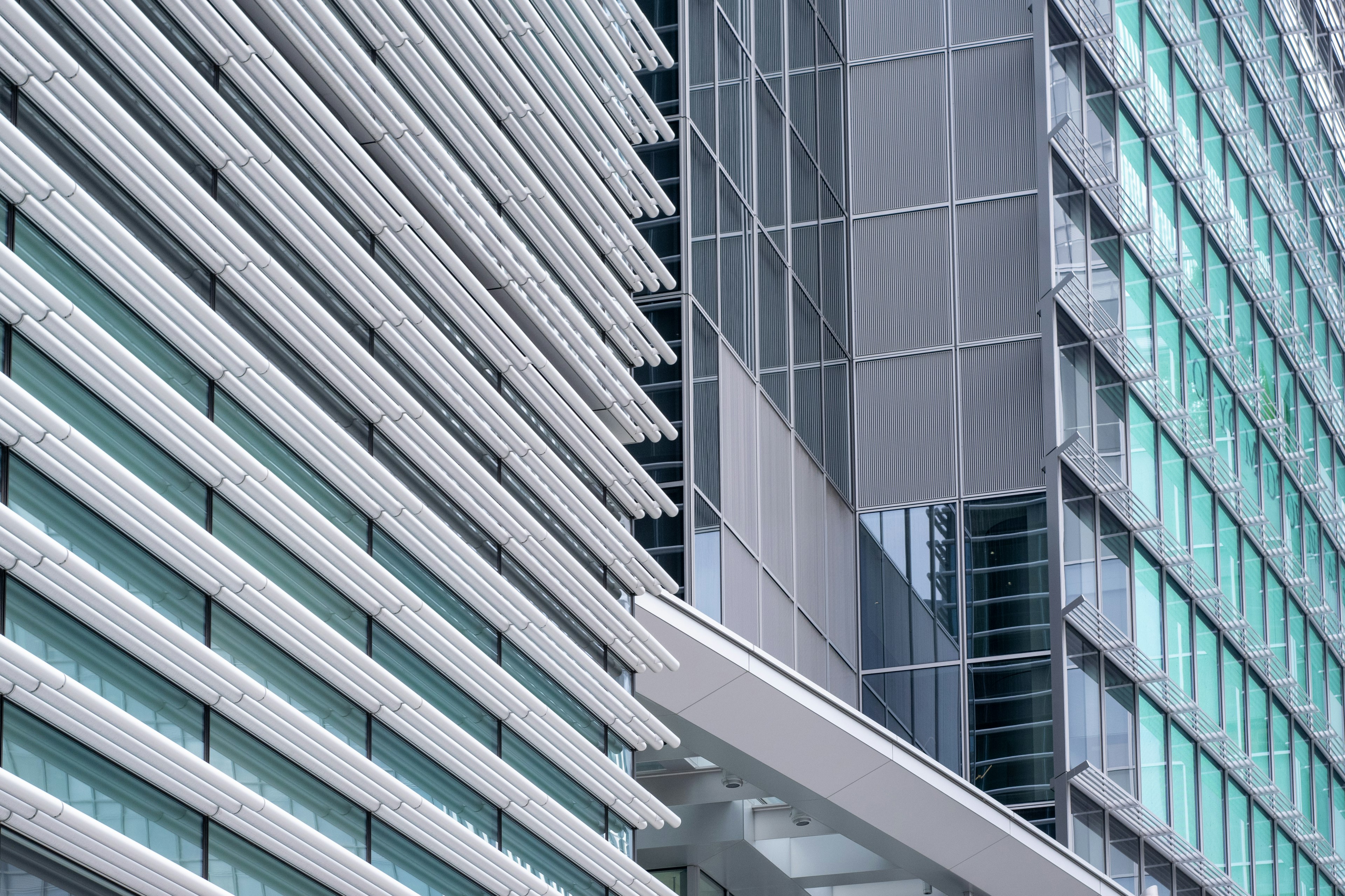 Extérieur d'un bâtiment moderne avec façade en verre rayé et métal