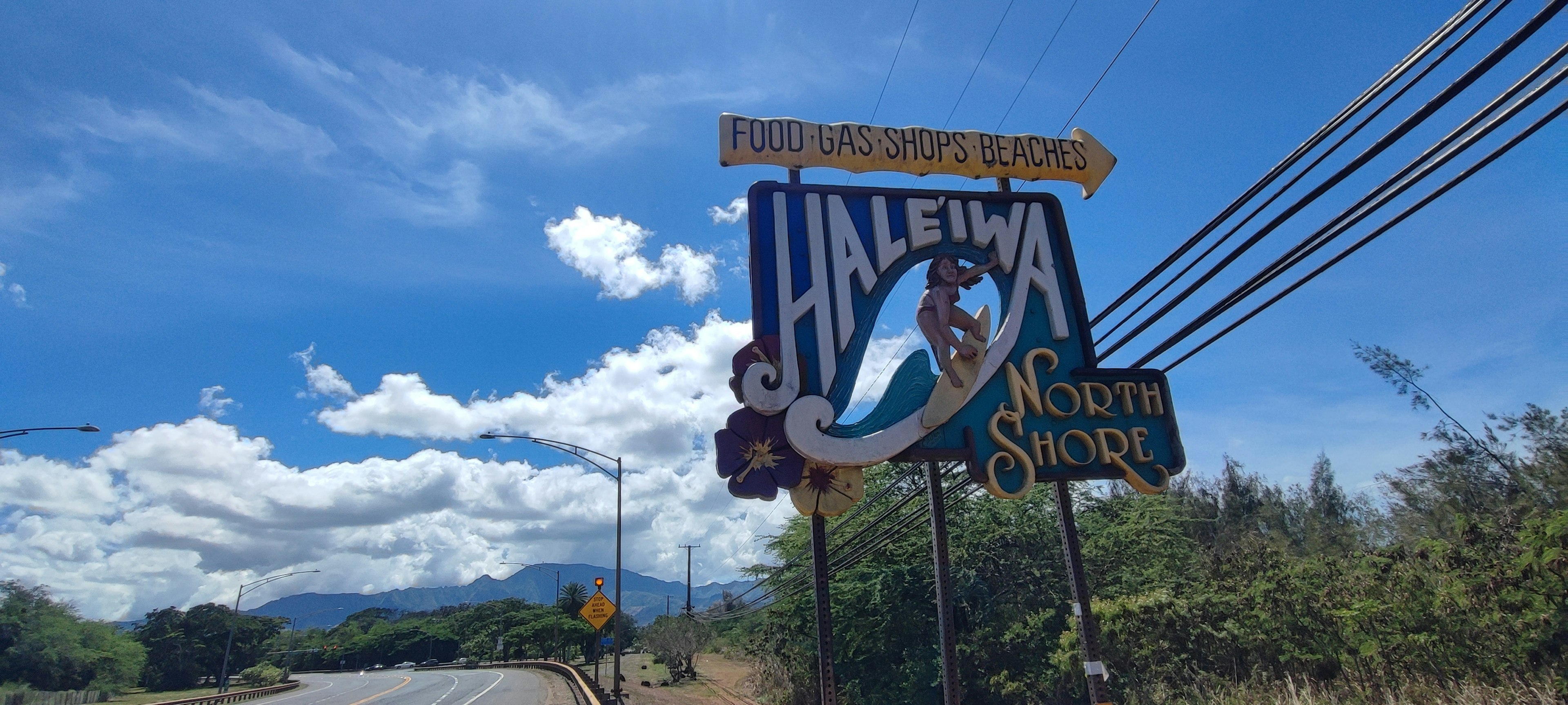 Un cartello colorato di Haleiwa sotto un cielo azzurro