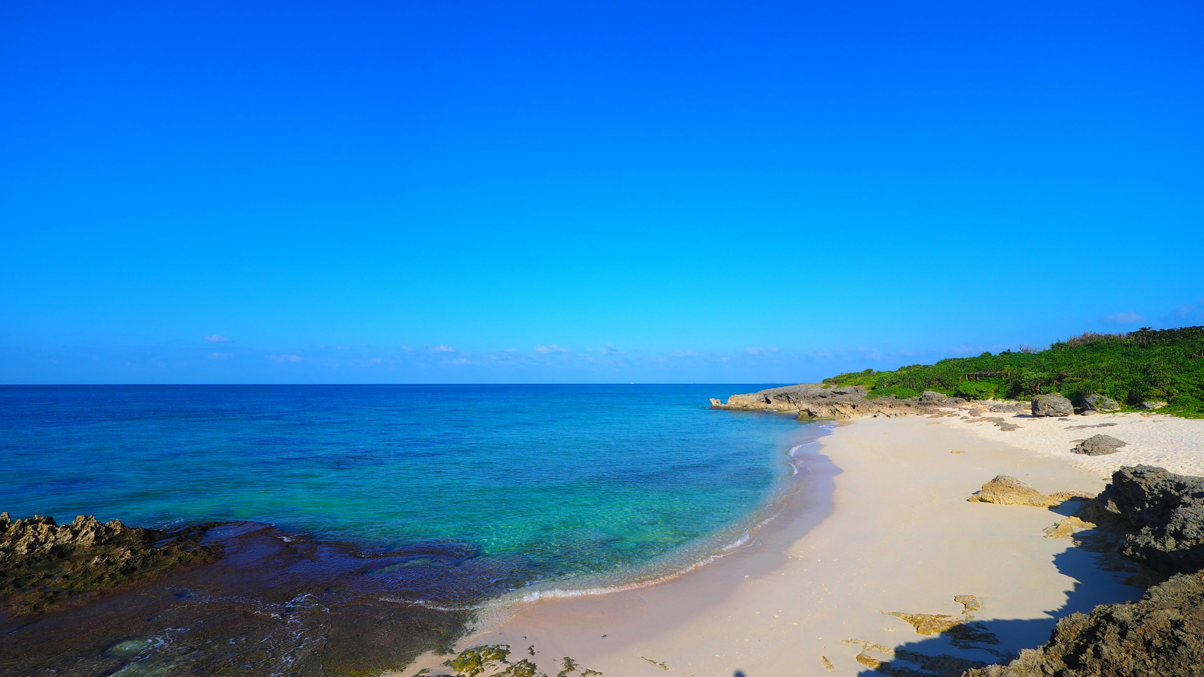 ทิวทัศน์ชายหาดที่สวยงามพร้อมมหาสมุทรสีน้ำเงินและชายหาดทรายขาว