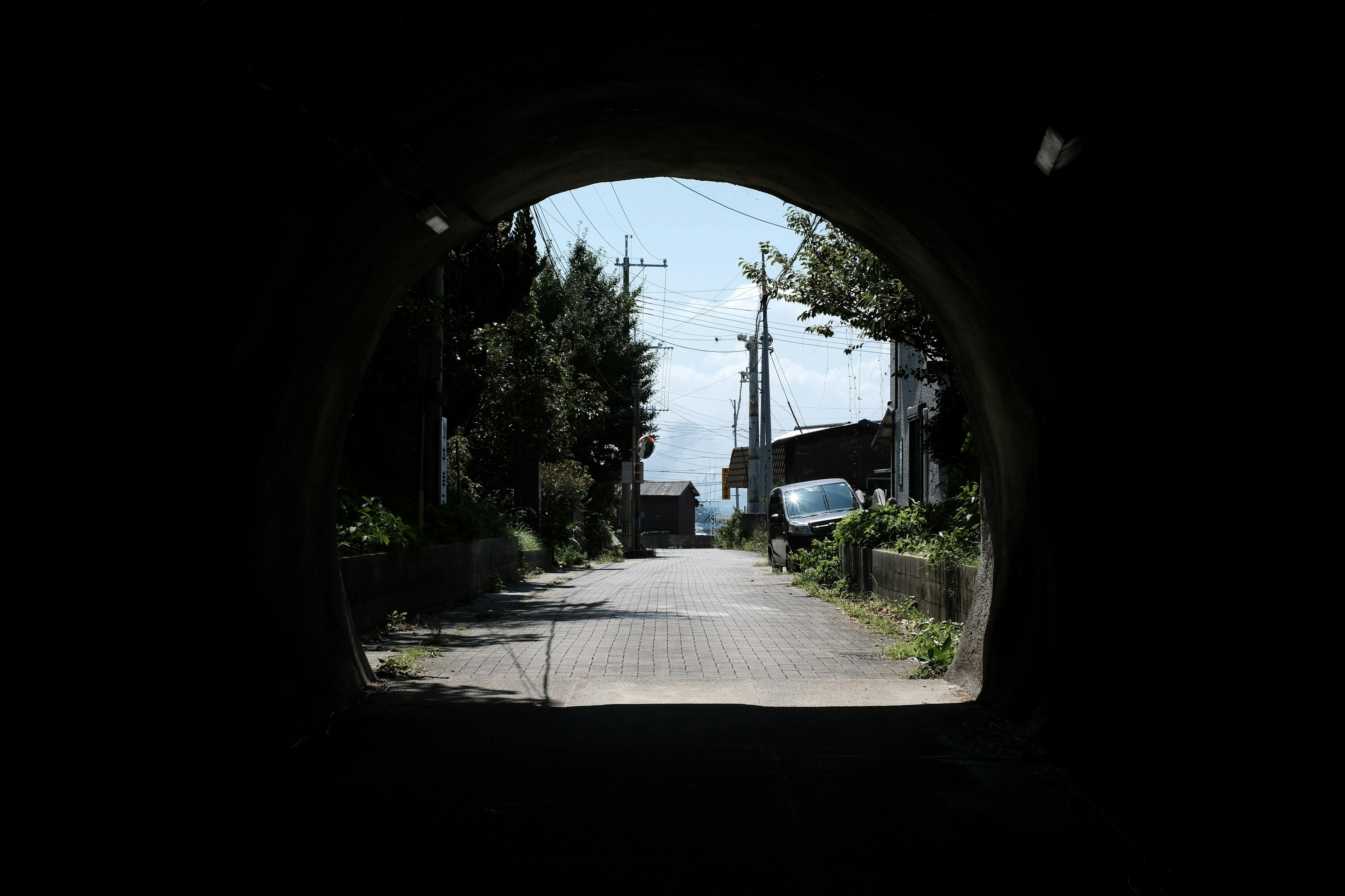 Vista de un camino brillante y cielo azul a través de un túnel