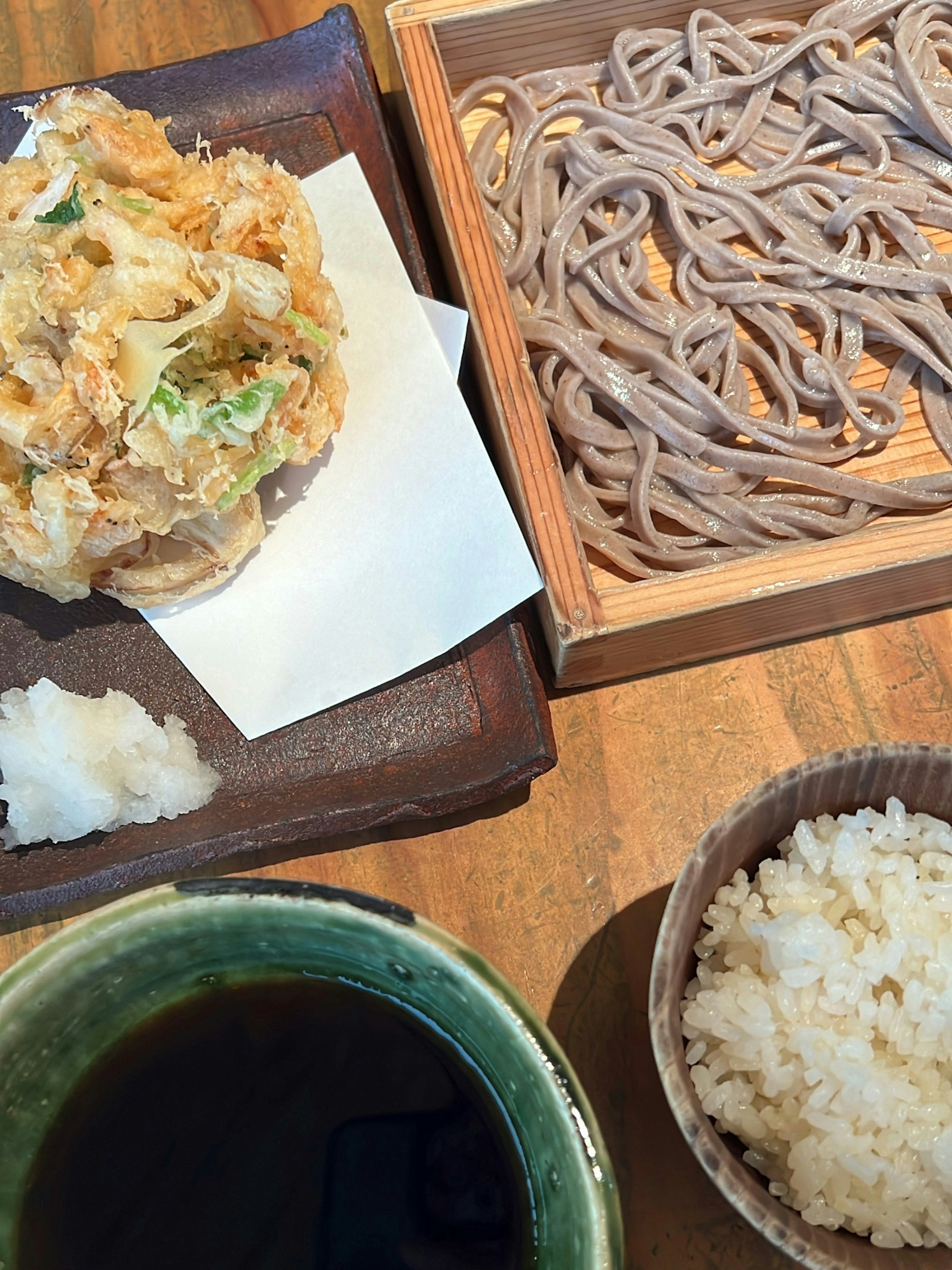 Traditional Japanese meal featuring soba noodles tempura rice and dipping sauce