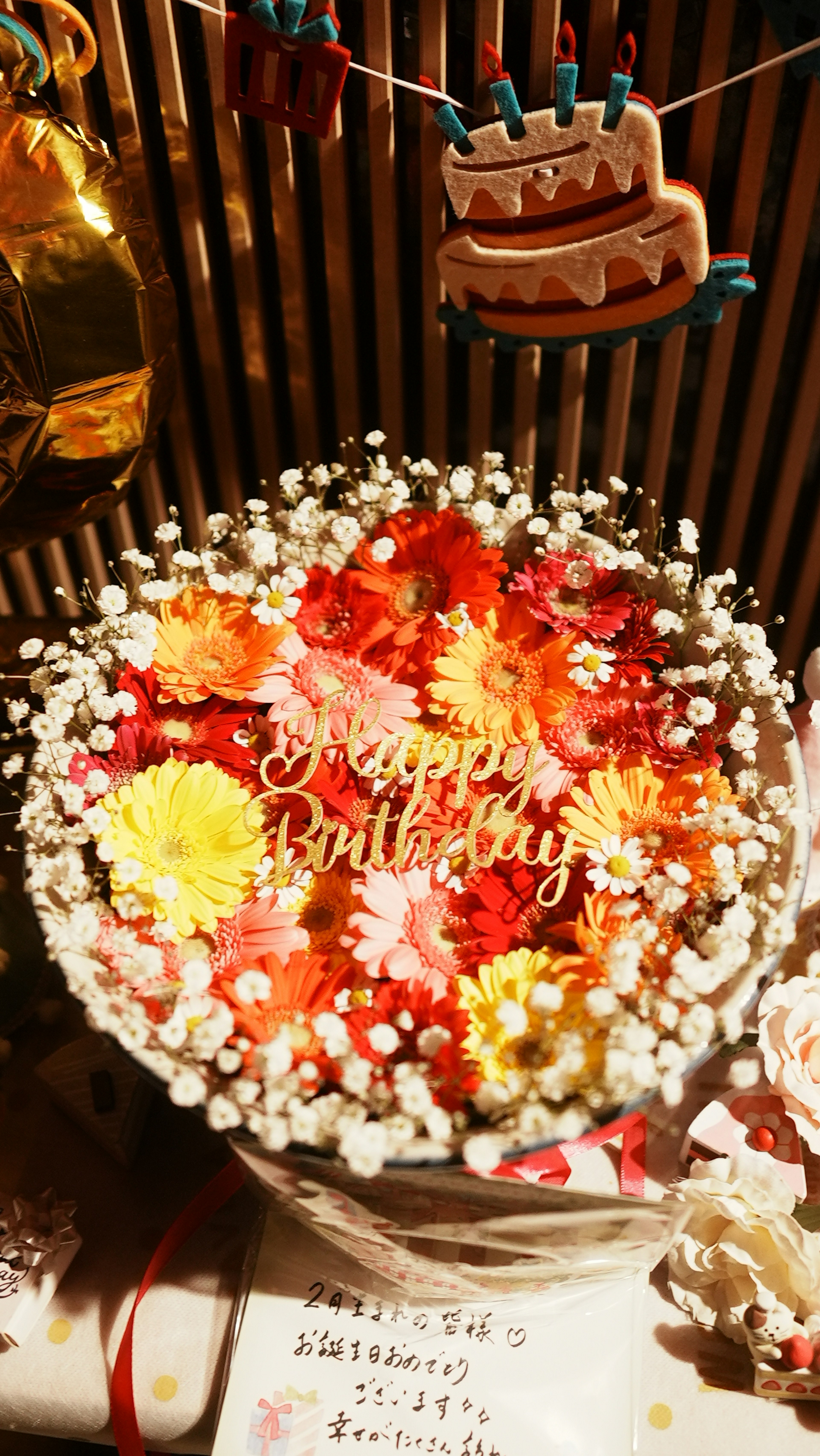 Fleurs colorées avec un message 'Joyeux Anniversaire' sur un gâteau d'anniversaire