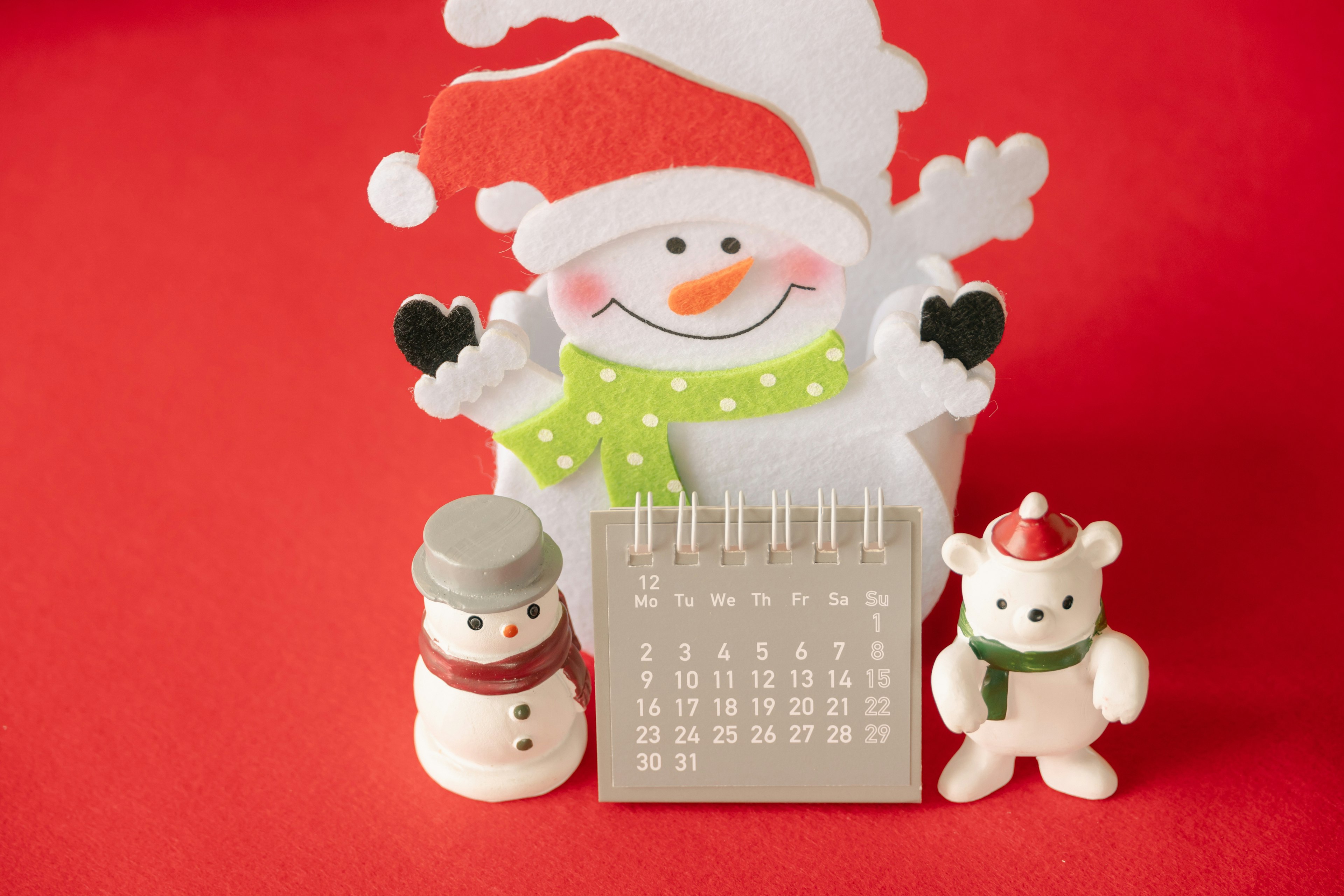 Decoraciones de muñeco de nieve y un calendario sobre un fondo rojo