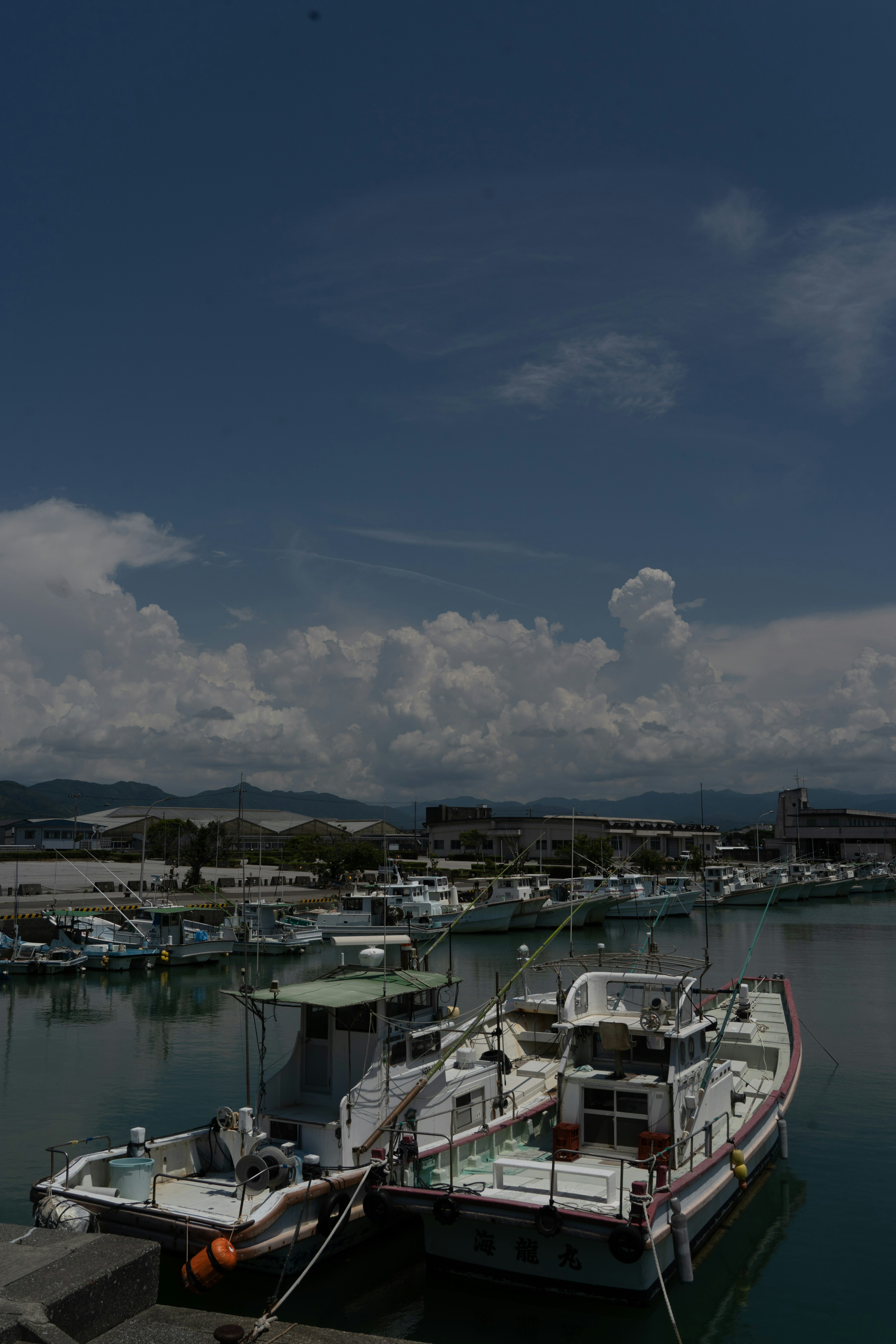 Fishing boat docked at a harbor under a blue sky