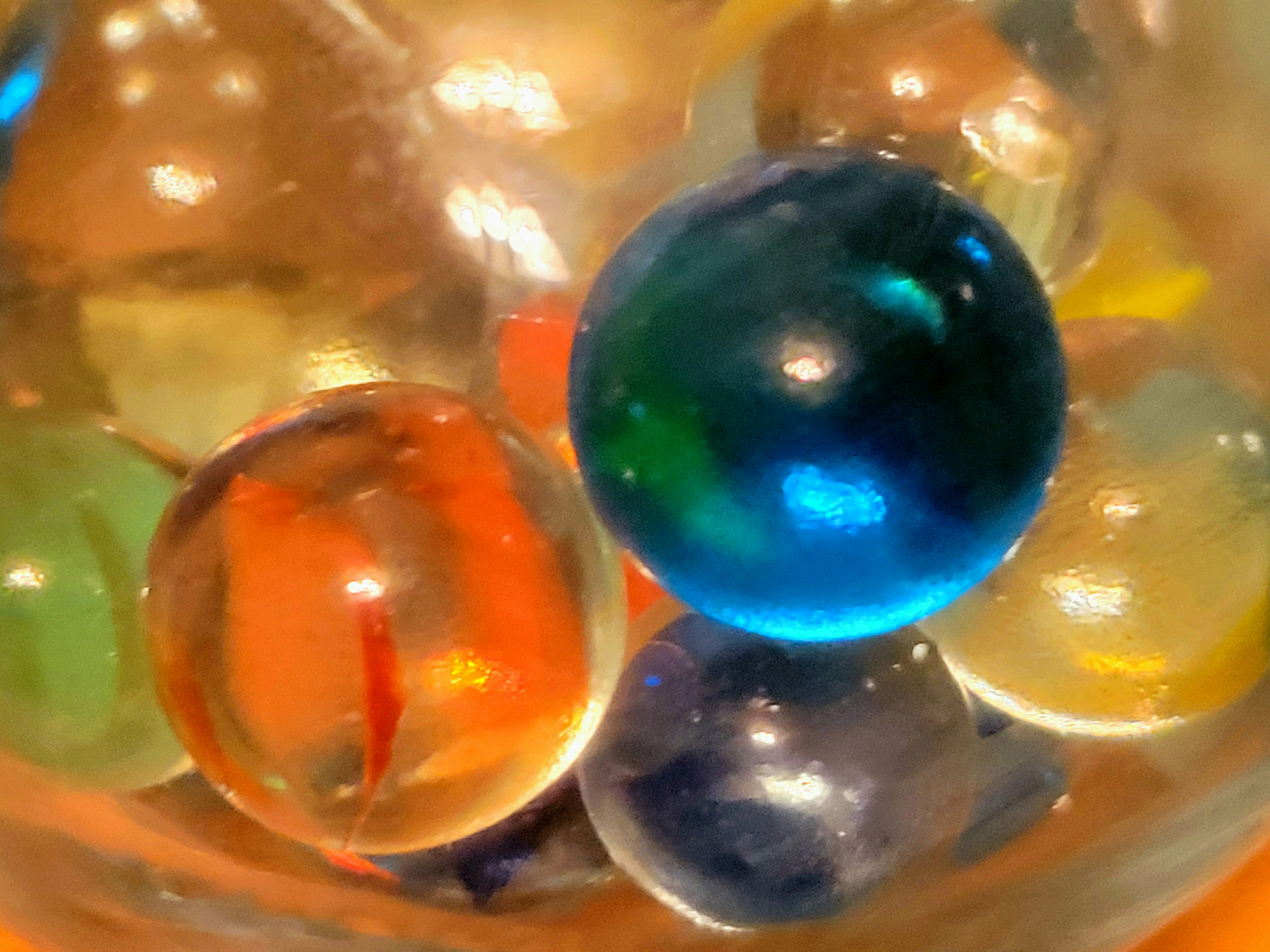 Close-up image of colorful marbles in a glass bowl