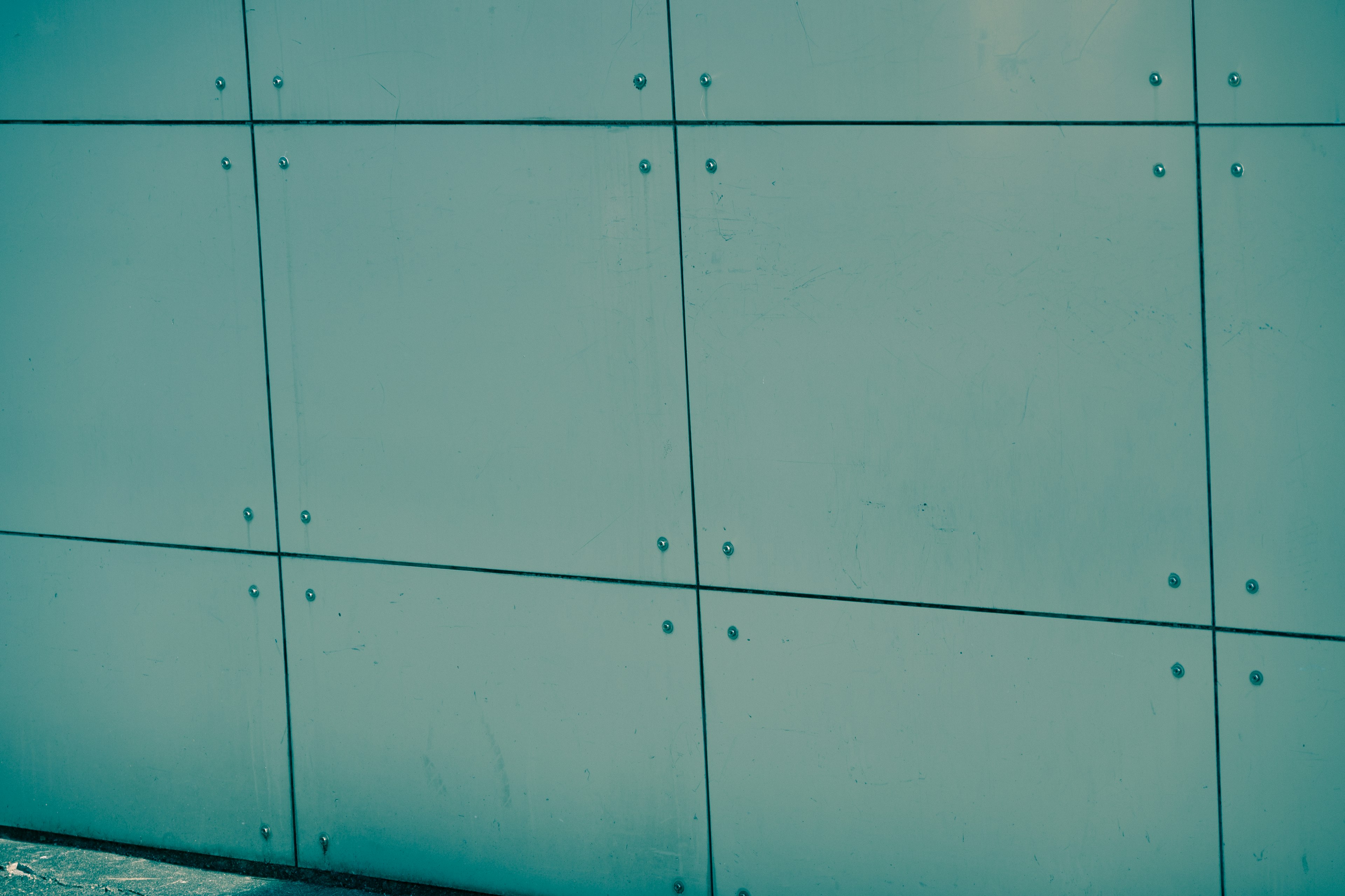 Detail of a bluish metal wall with evenly arranged panels