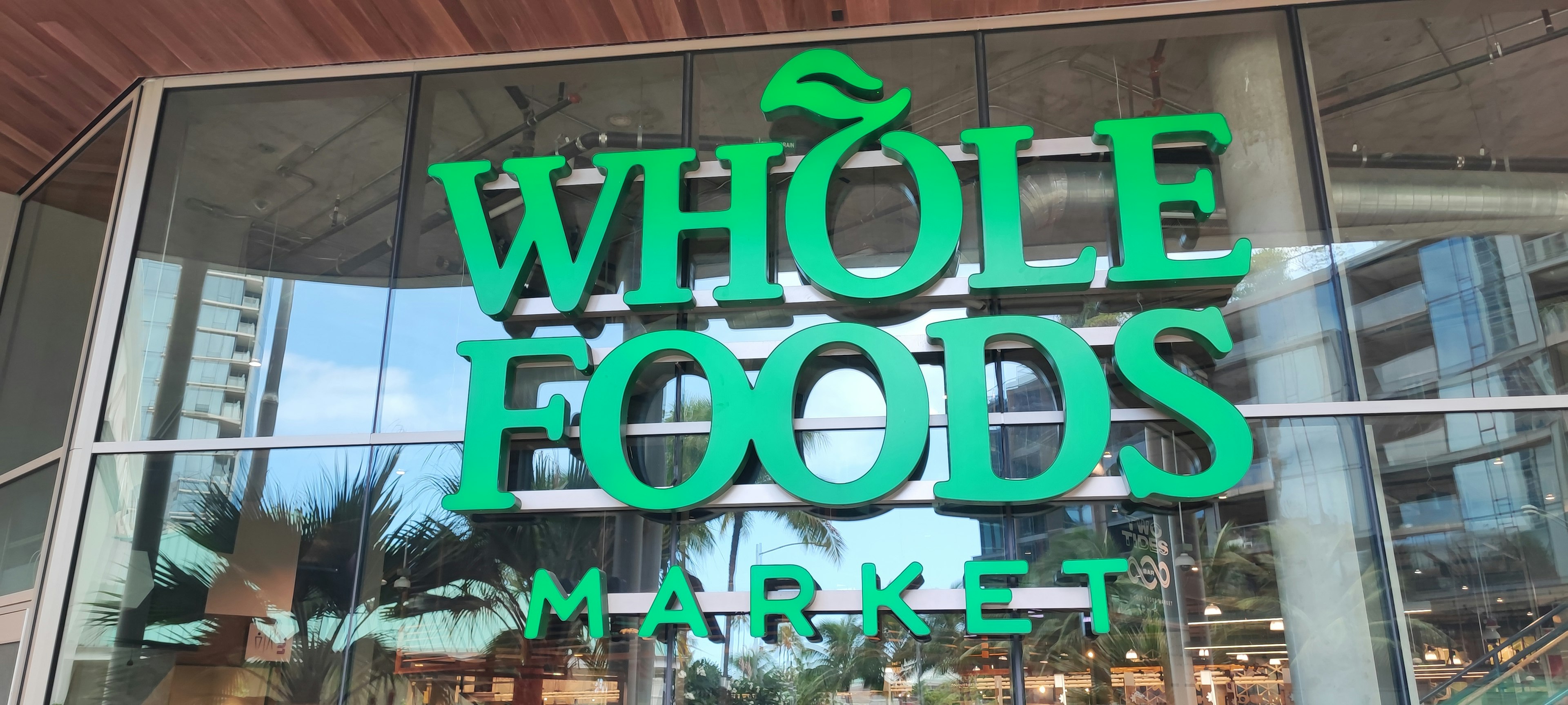 Vista exterior de Whole Foods Market con letrero verde