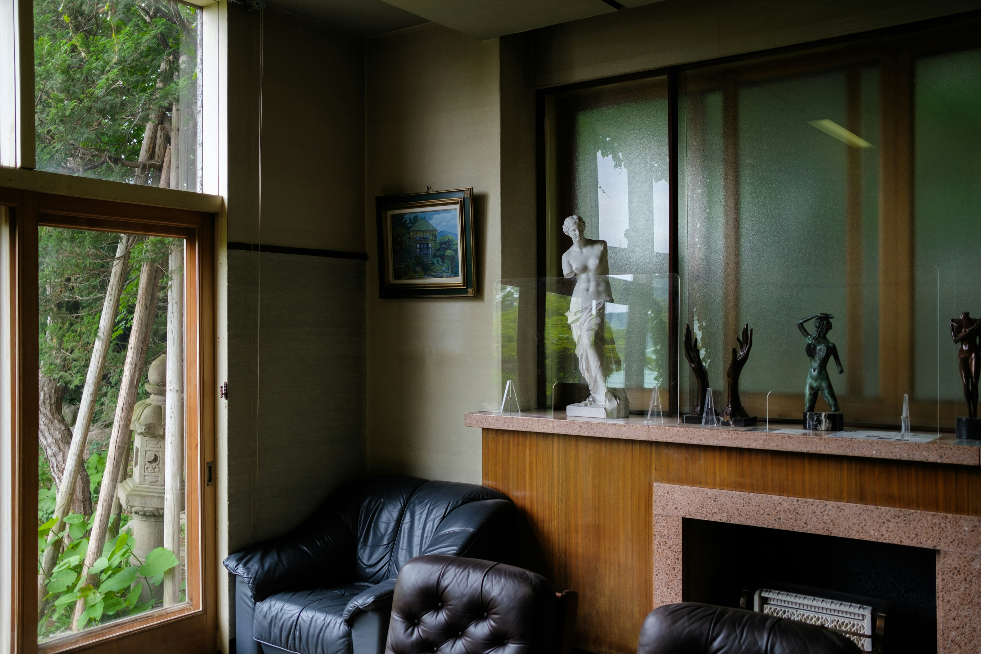 Corner of a modern living room featuring sculptures and a window view