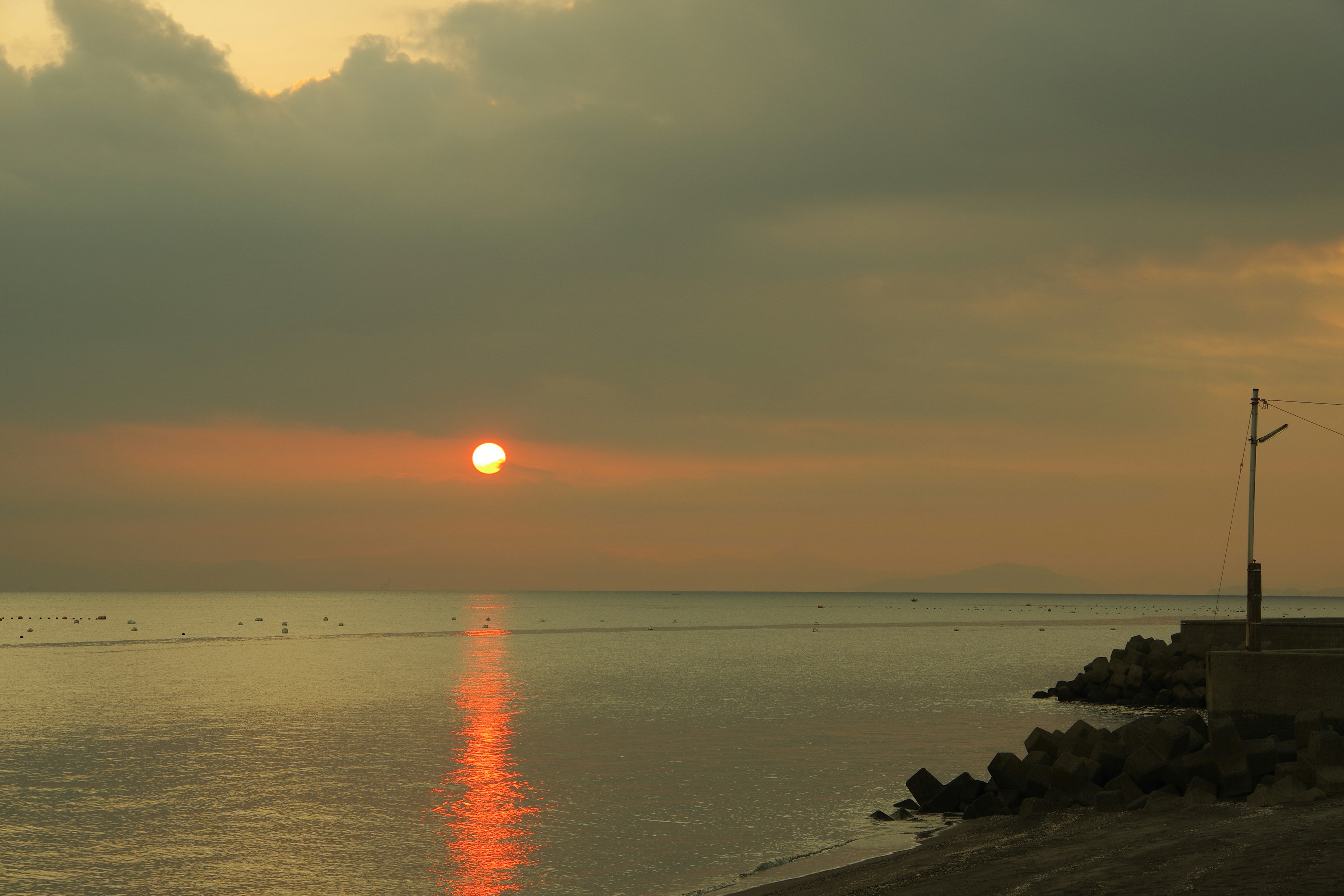 Sunset over the sea with orange reflections on calm water