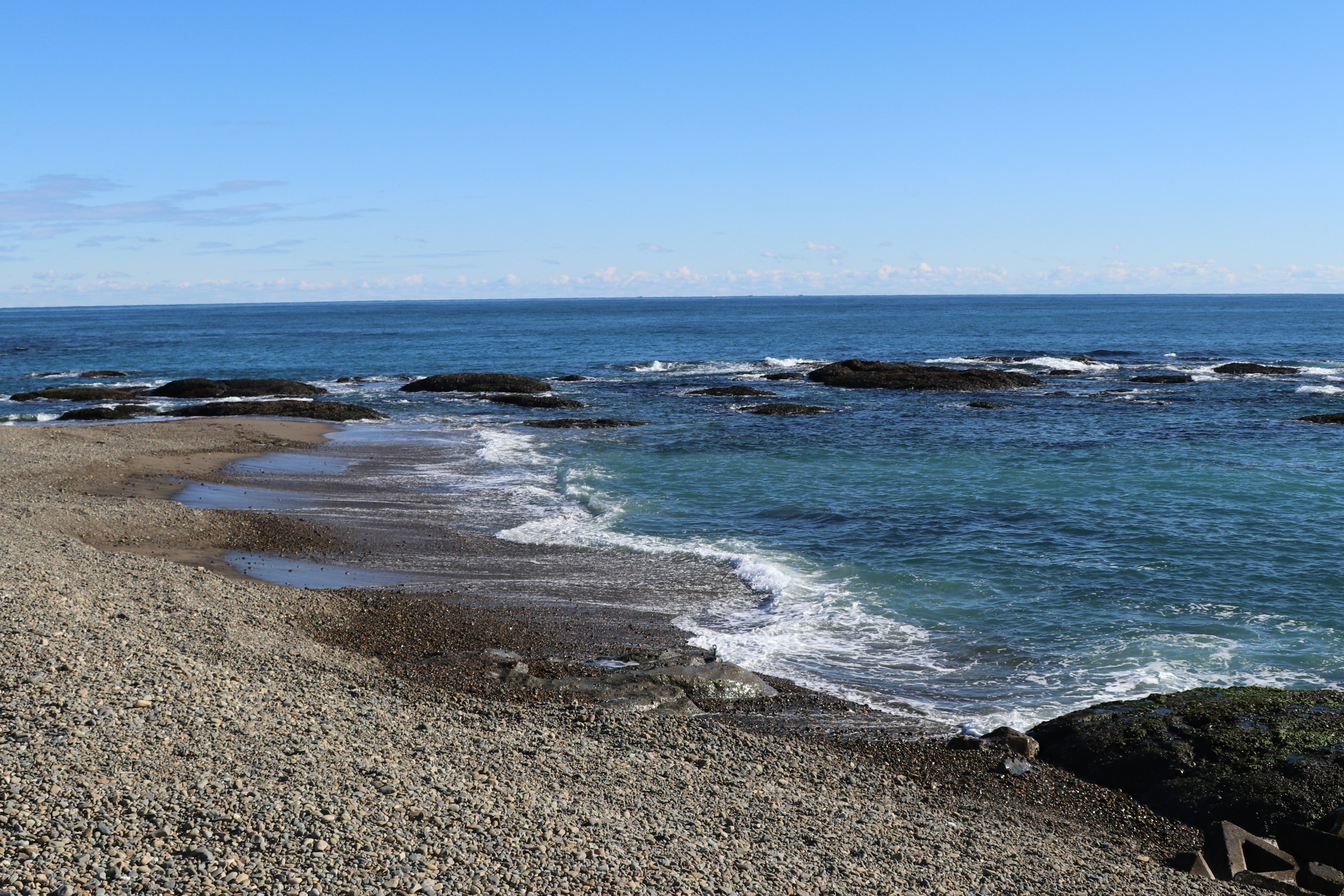 Vista escénica de una playa con océano azul y costa rocosa