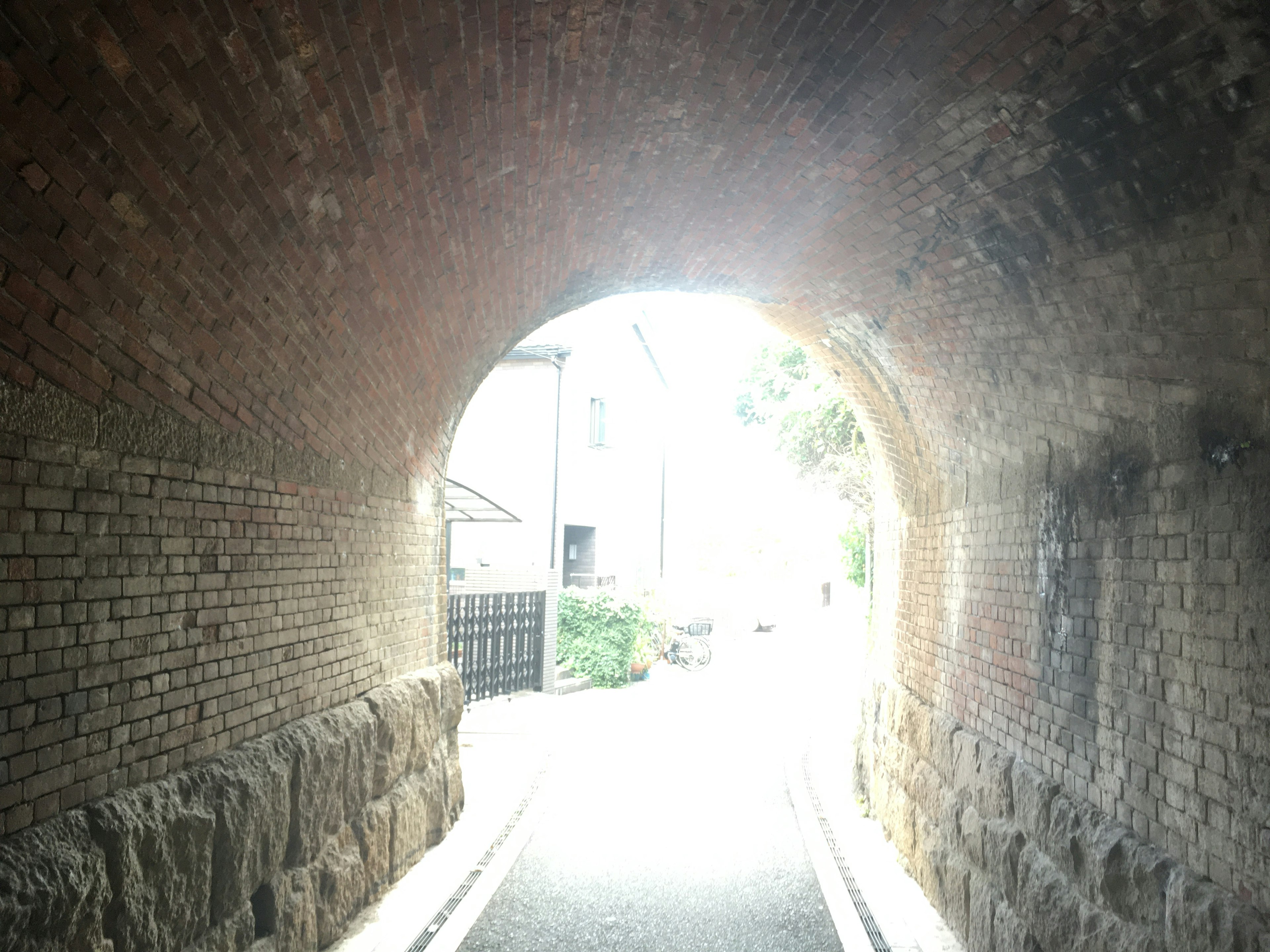 Vue de l'intérieur d'un tunnel en briques vers une lumière vive