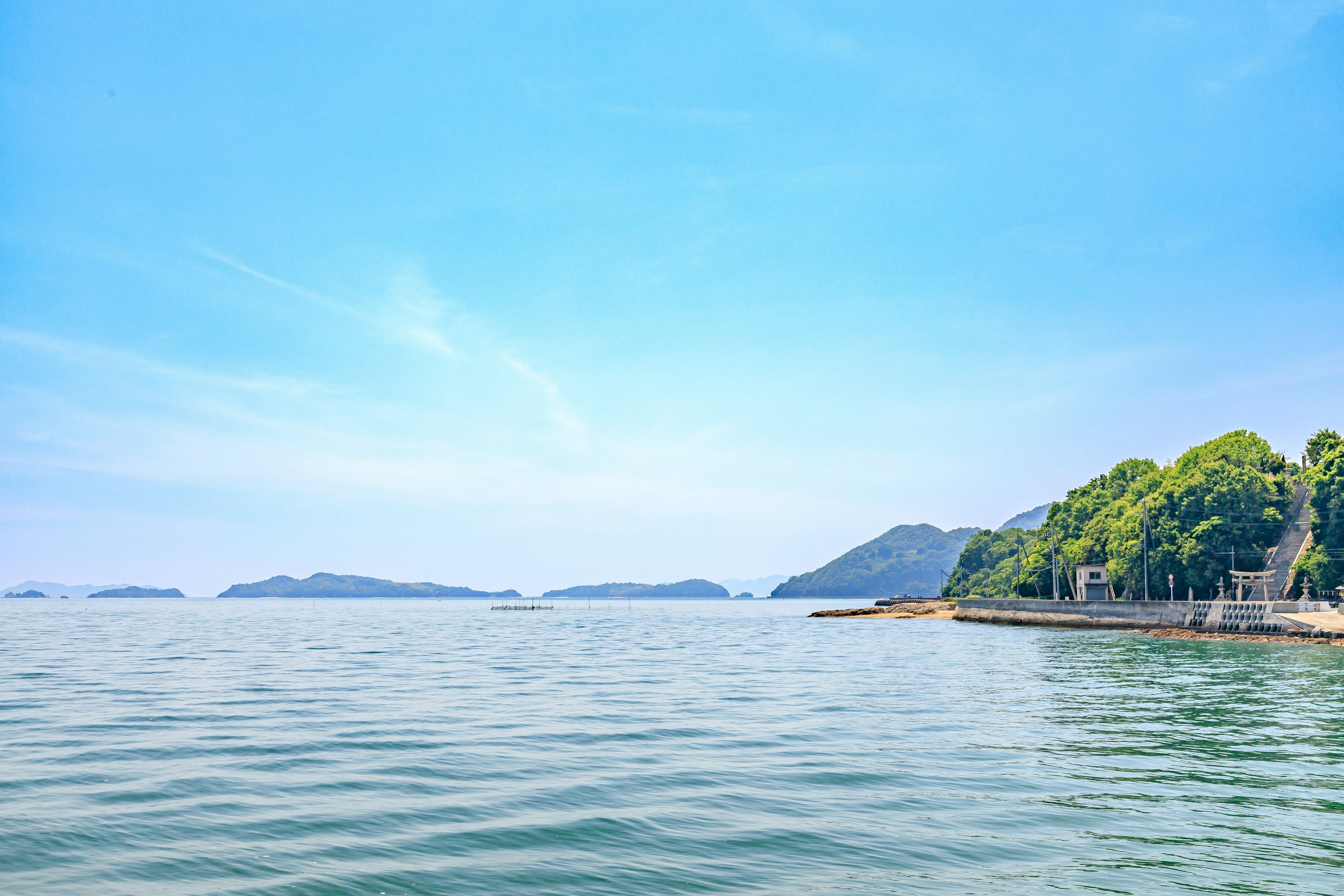 平靜的海洋和藍天的風景，綠色島嶼可見