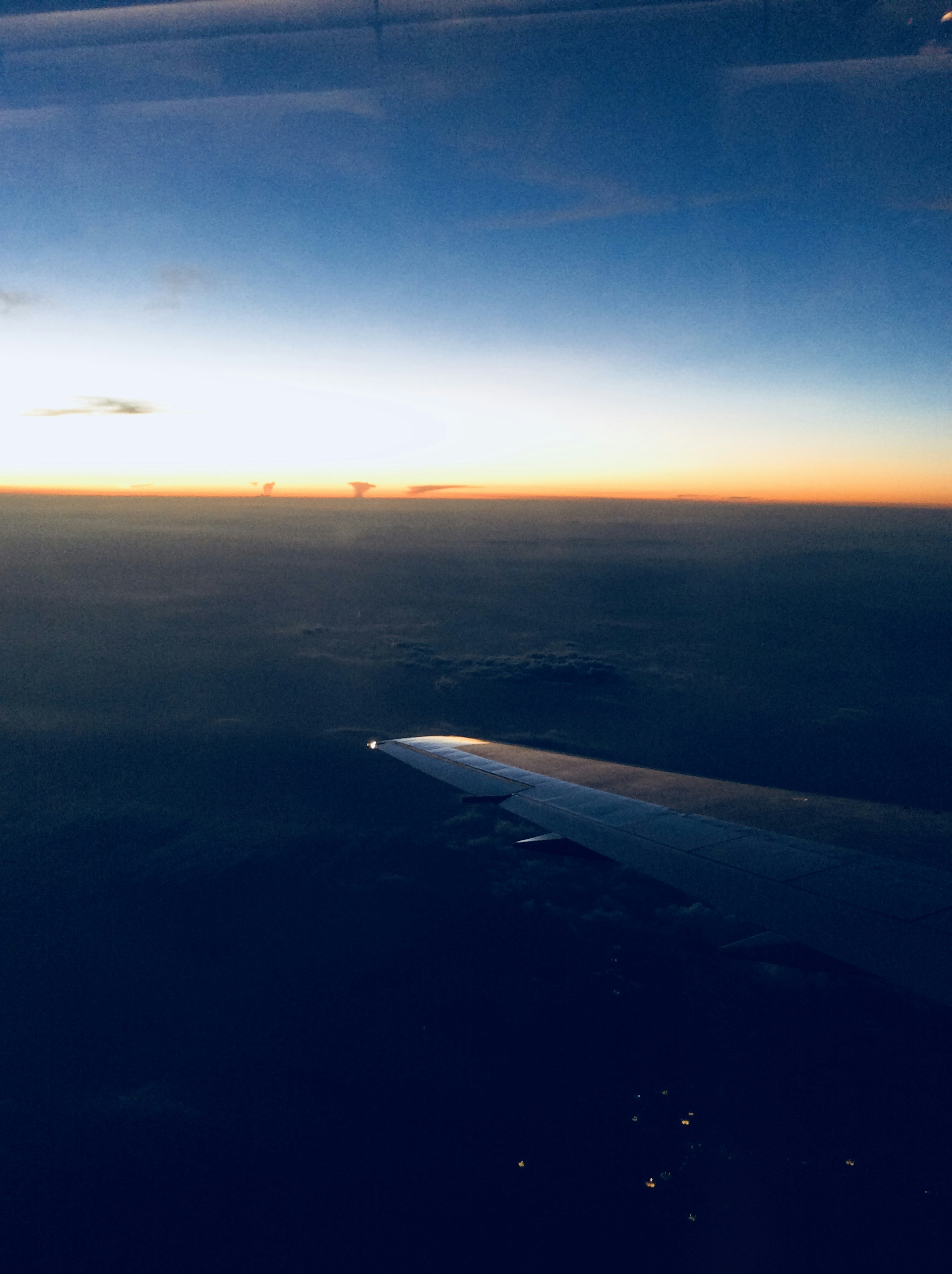 Sonnenuntergangshimmel aus einem Flugzeugfenster mit Flügelspitze