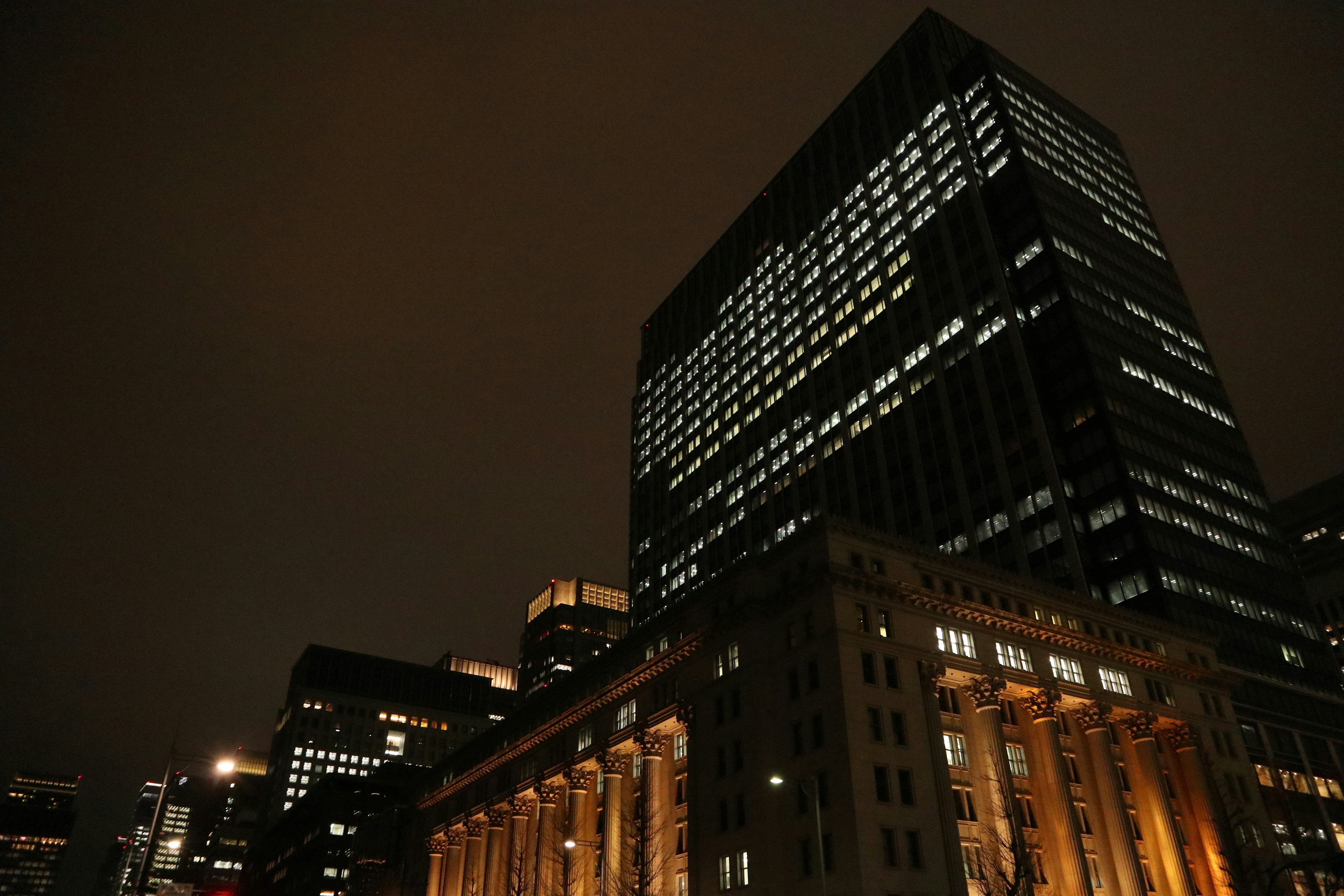 Urban skyline at night featuring tall buildings and illuminated architecture