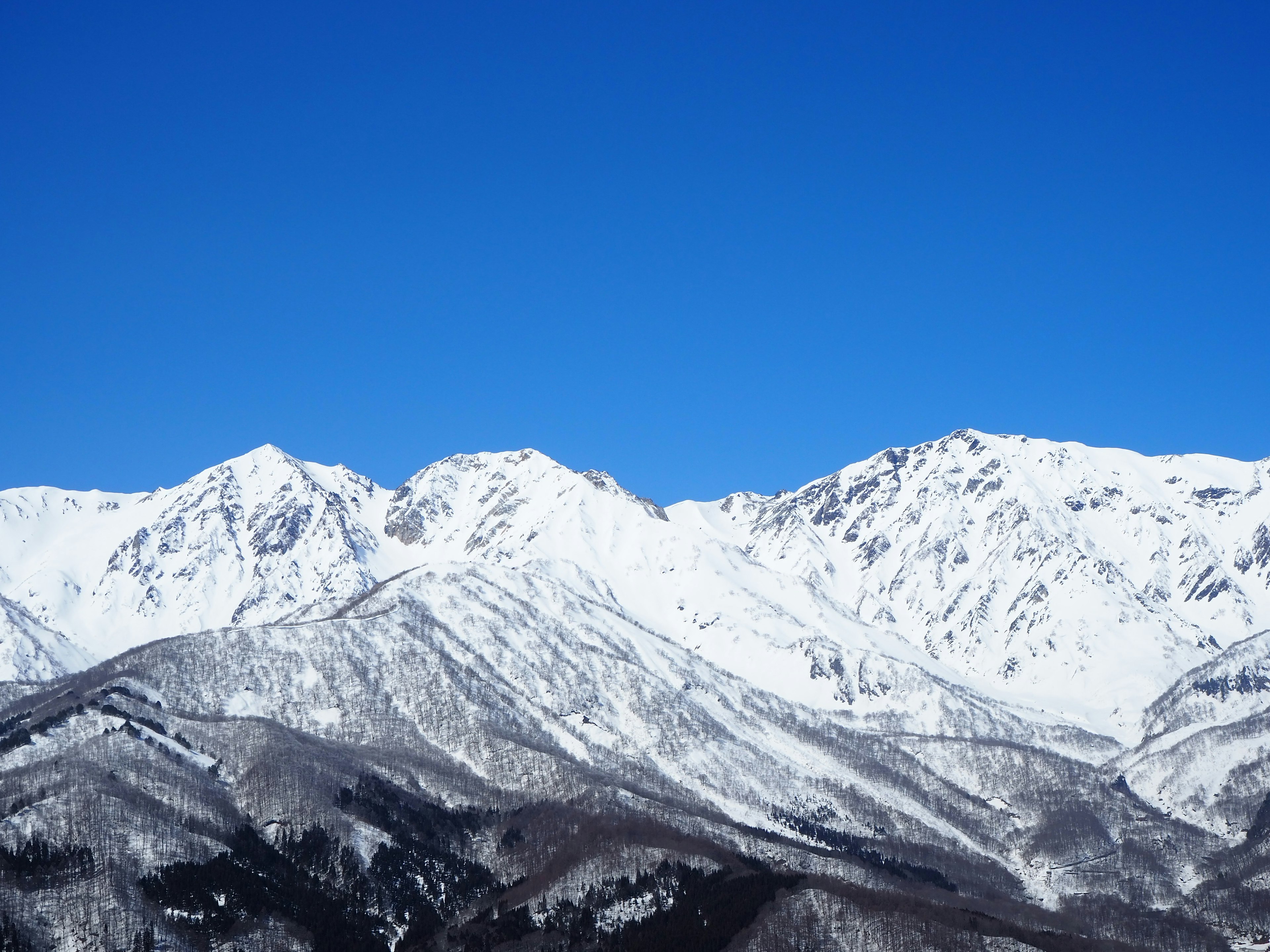 Schneebedeckte Berge unter einem klaren blauen Himmel