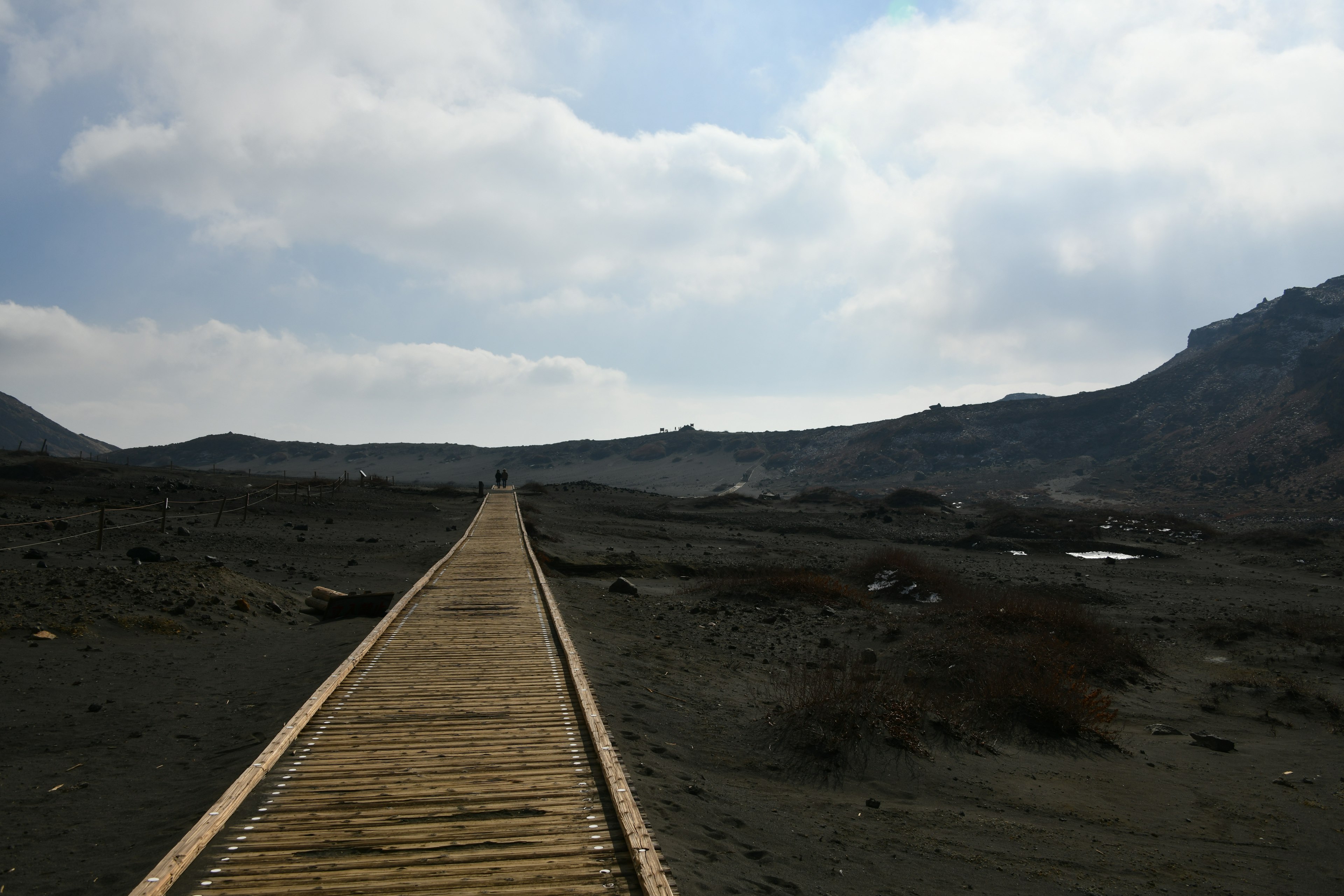 Passerelle en bois s'étendant sur un paysage sous un ciel nuageux