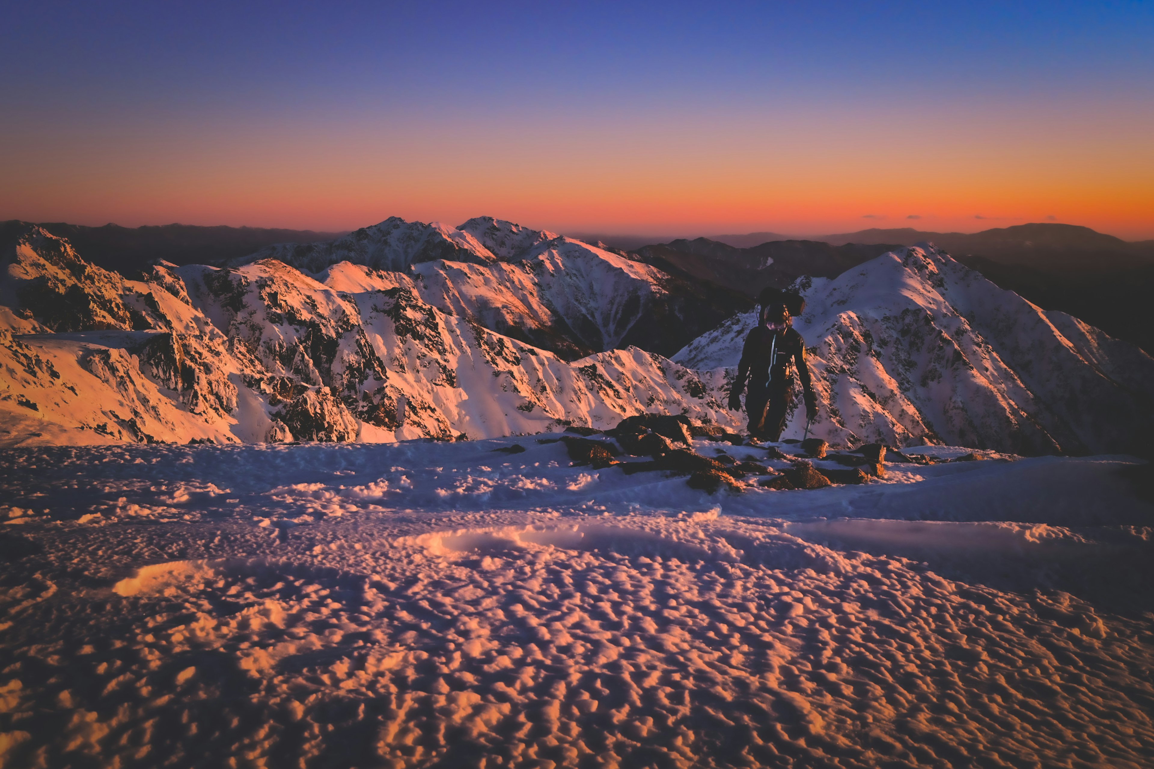 Snow-covered mountains with a sunset sky