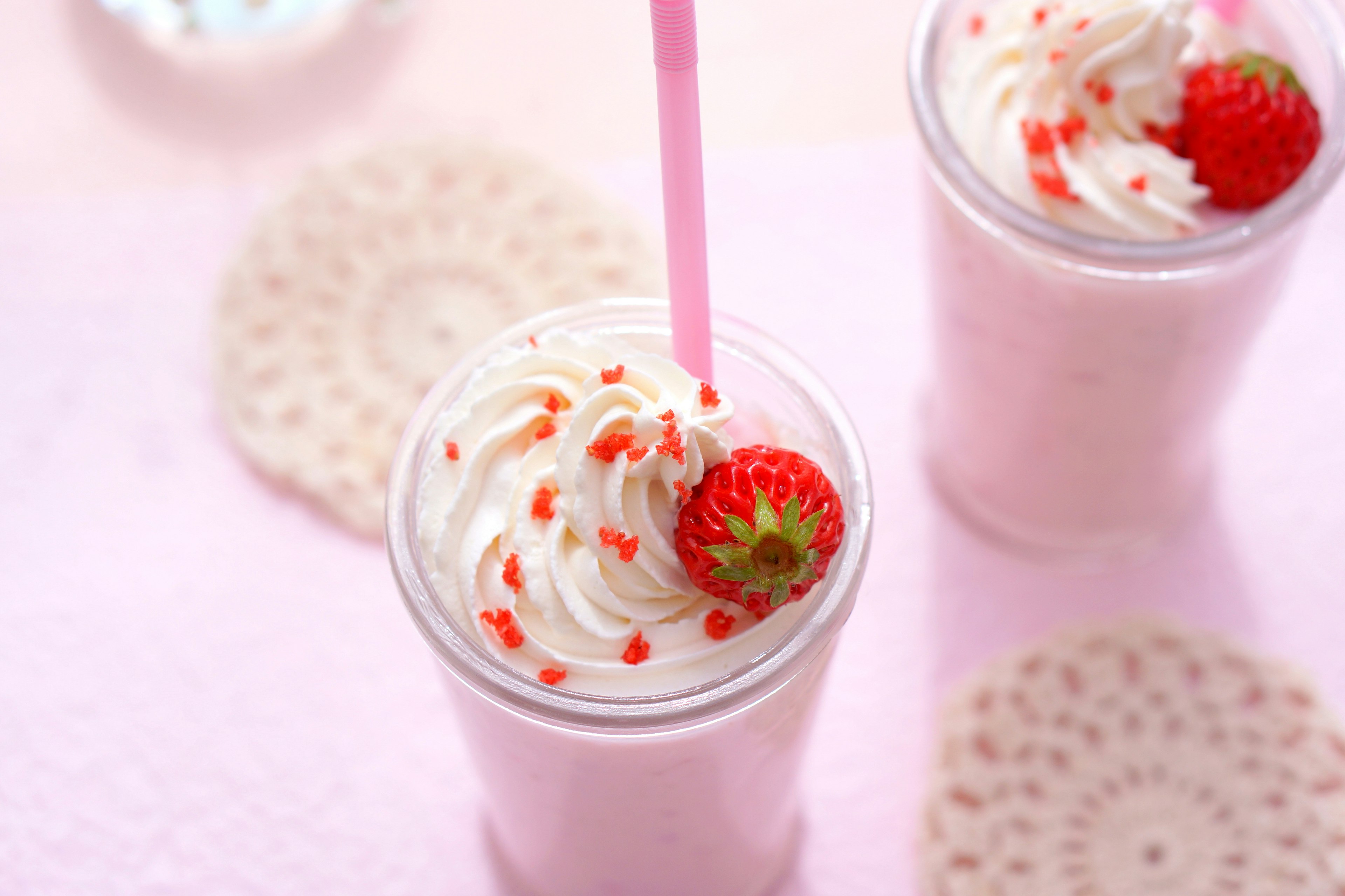 Strawberry shake topped with cream and a strawberry in a cup