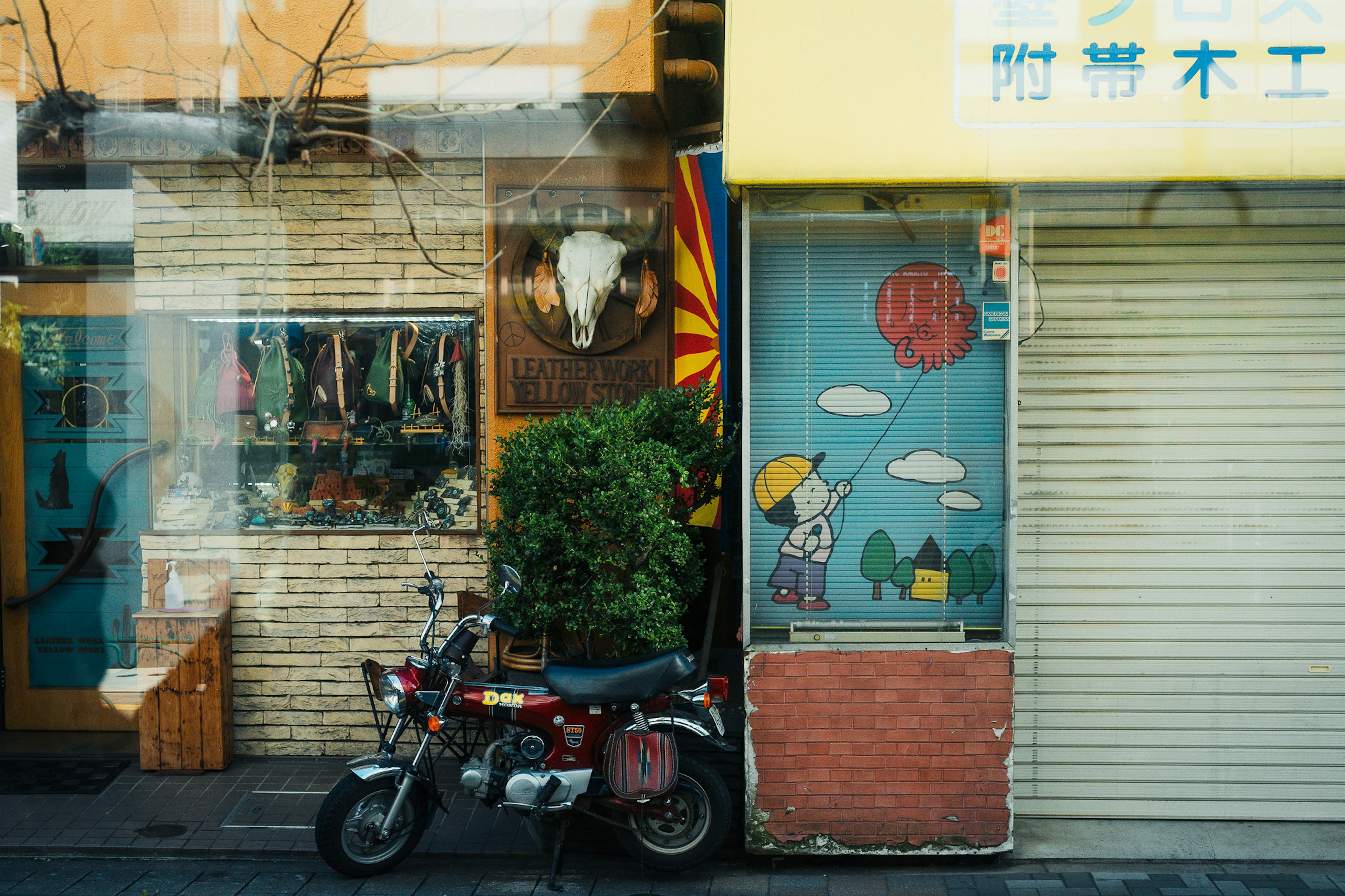 Bunte Schaufenster mit Dekorationen und einem Motorrad an einer Straßenecke