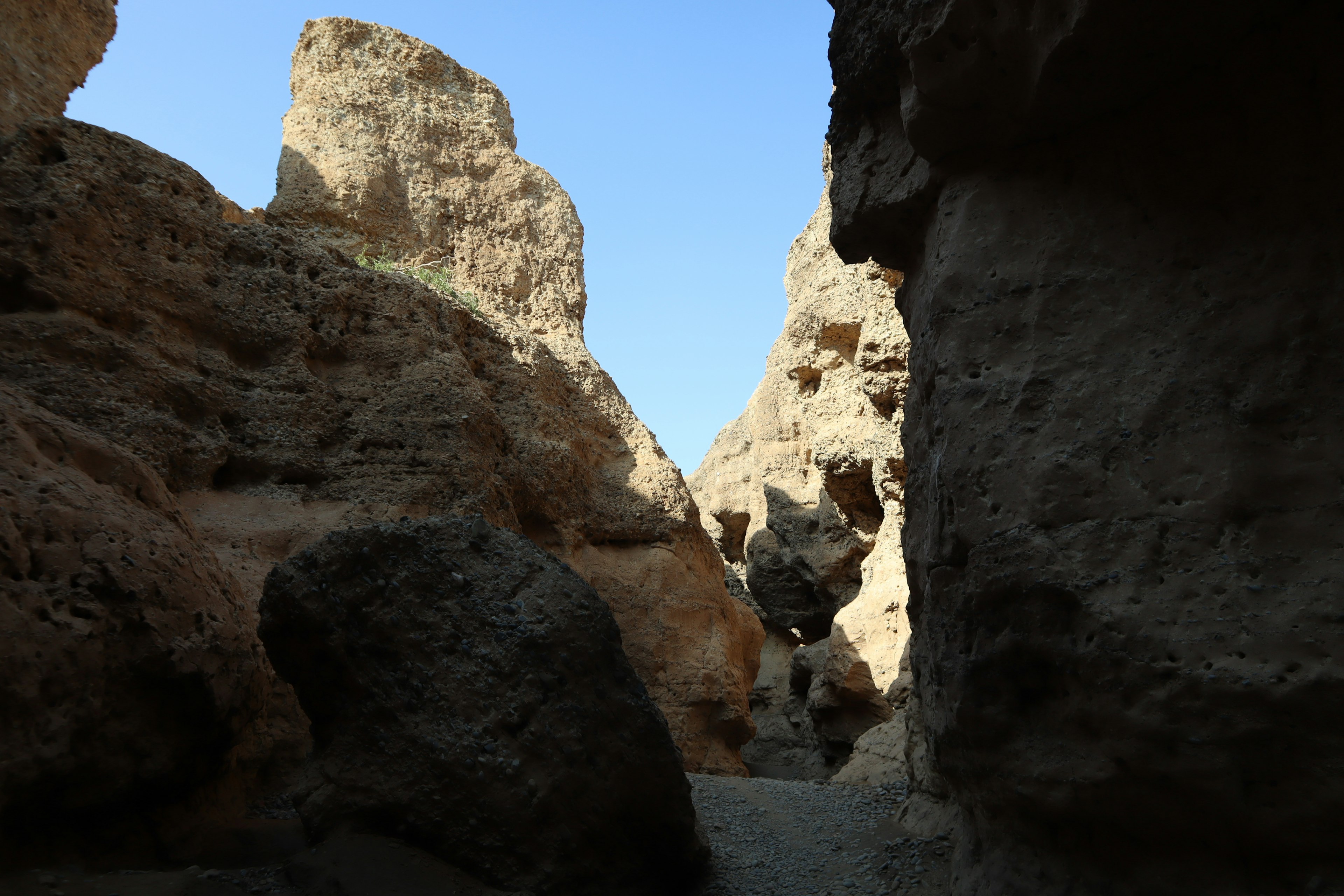 Rocky landscape with blue sky seen through a narrow canyon