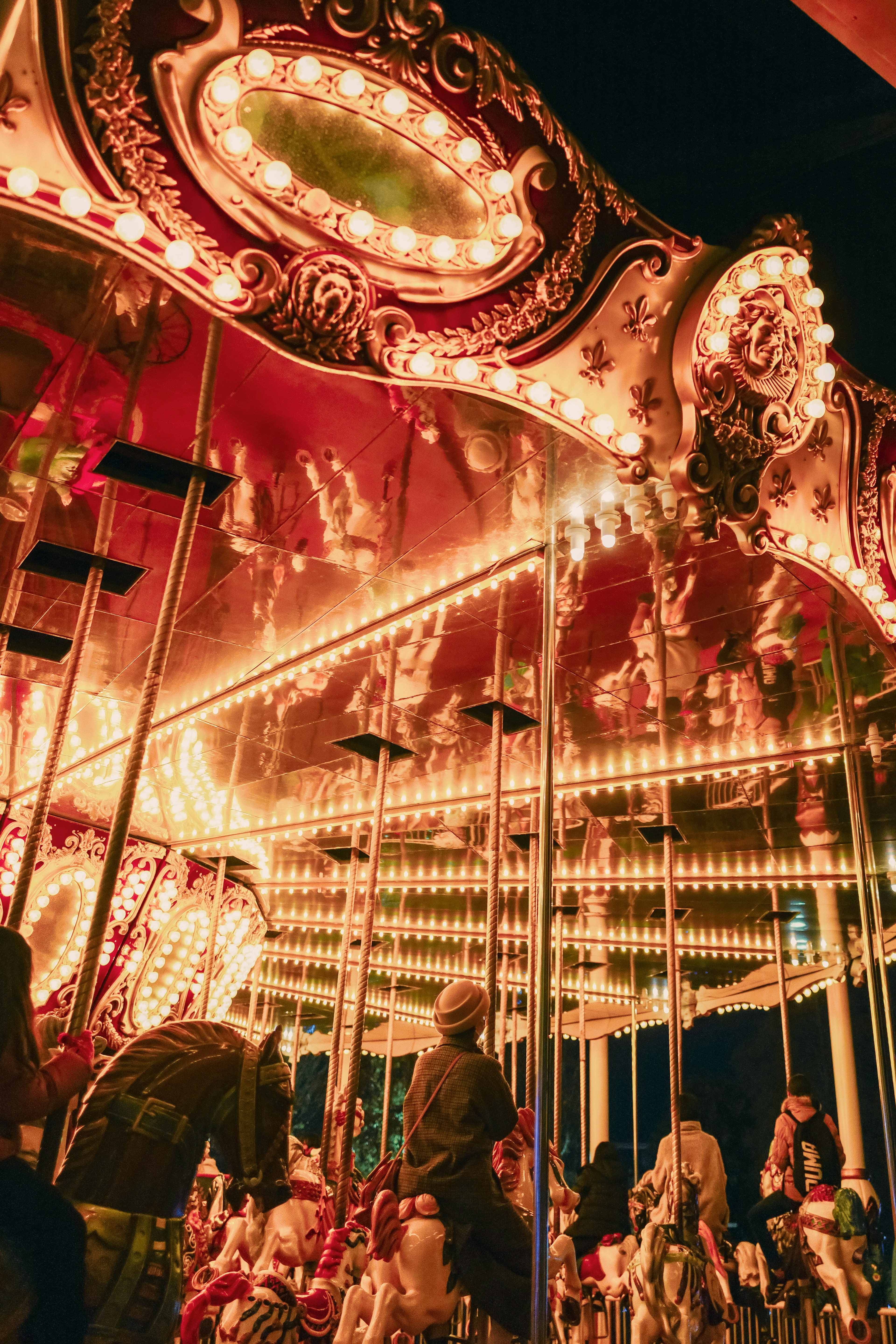 Interior de un carrusel iluminado con decoraciones ornamentadas y reflejos