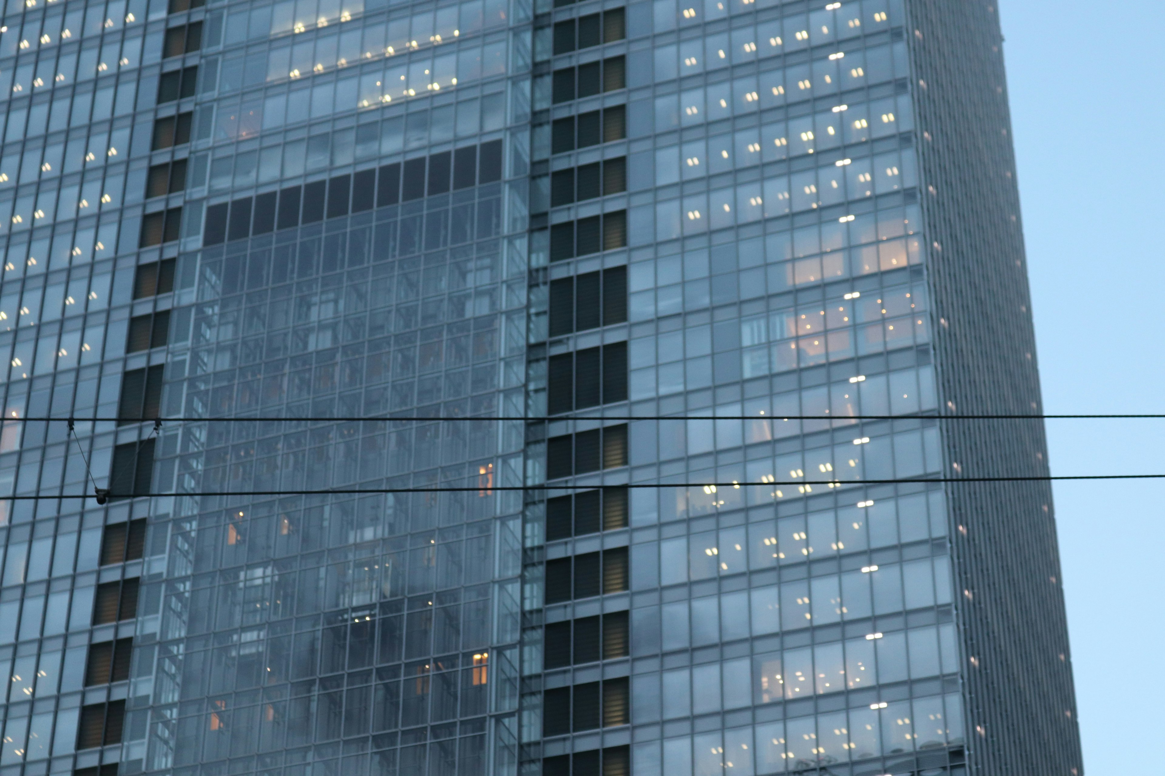 Glass facade of a high-rise building with illuminated offices