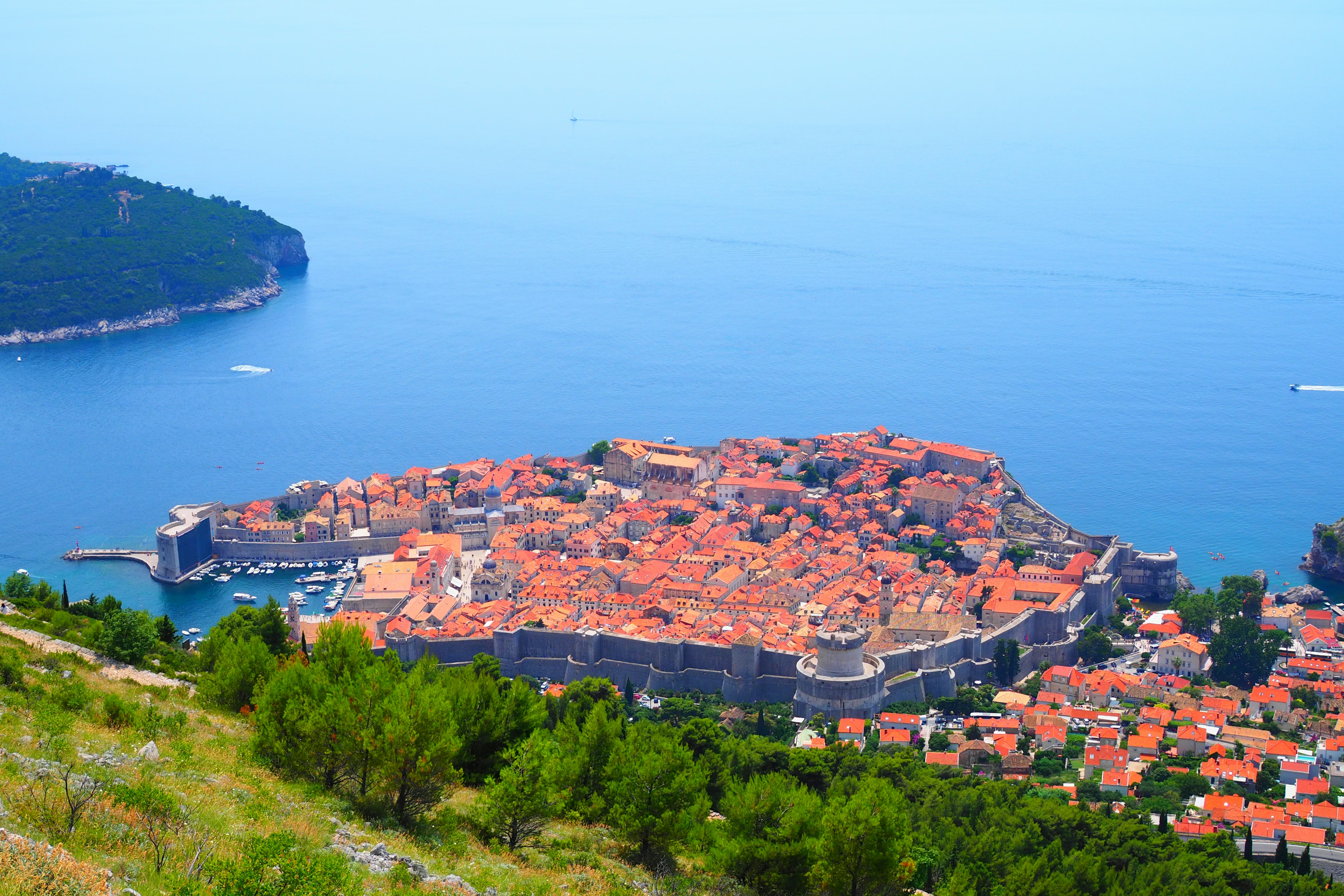 Une ville historique entourée d'une mer bleue avec des toits oranges