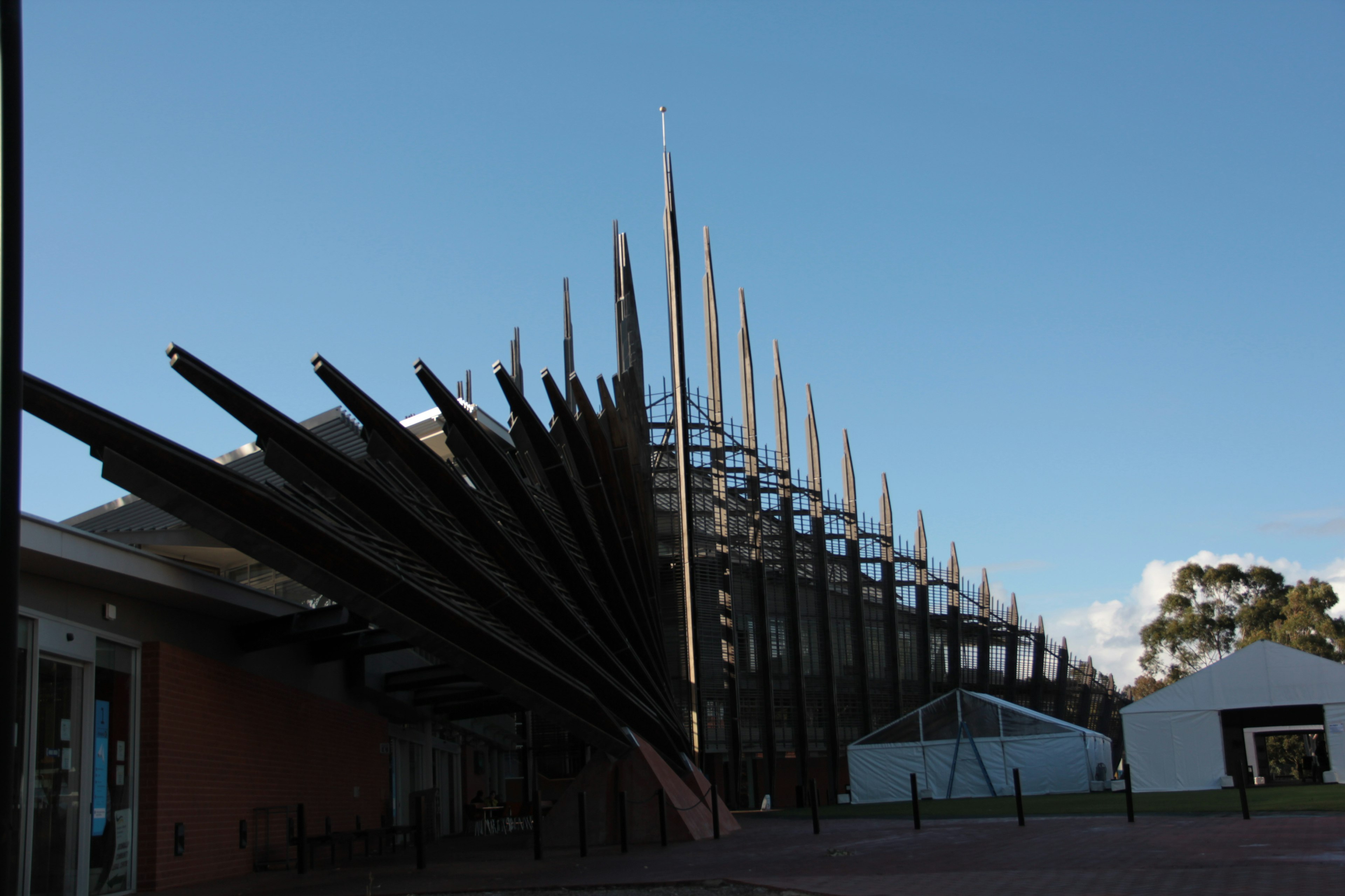 Unique architectural design of a building with striking pointed structures against a blue sky