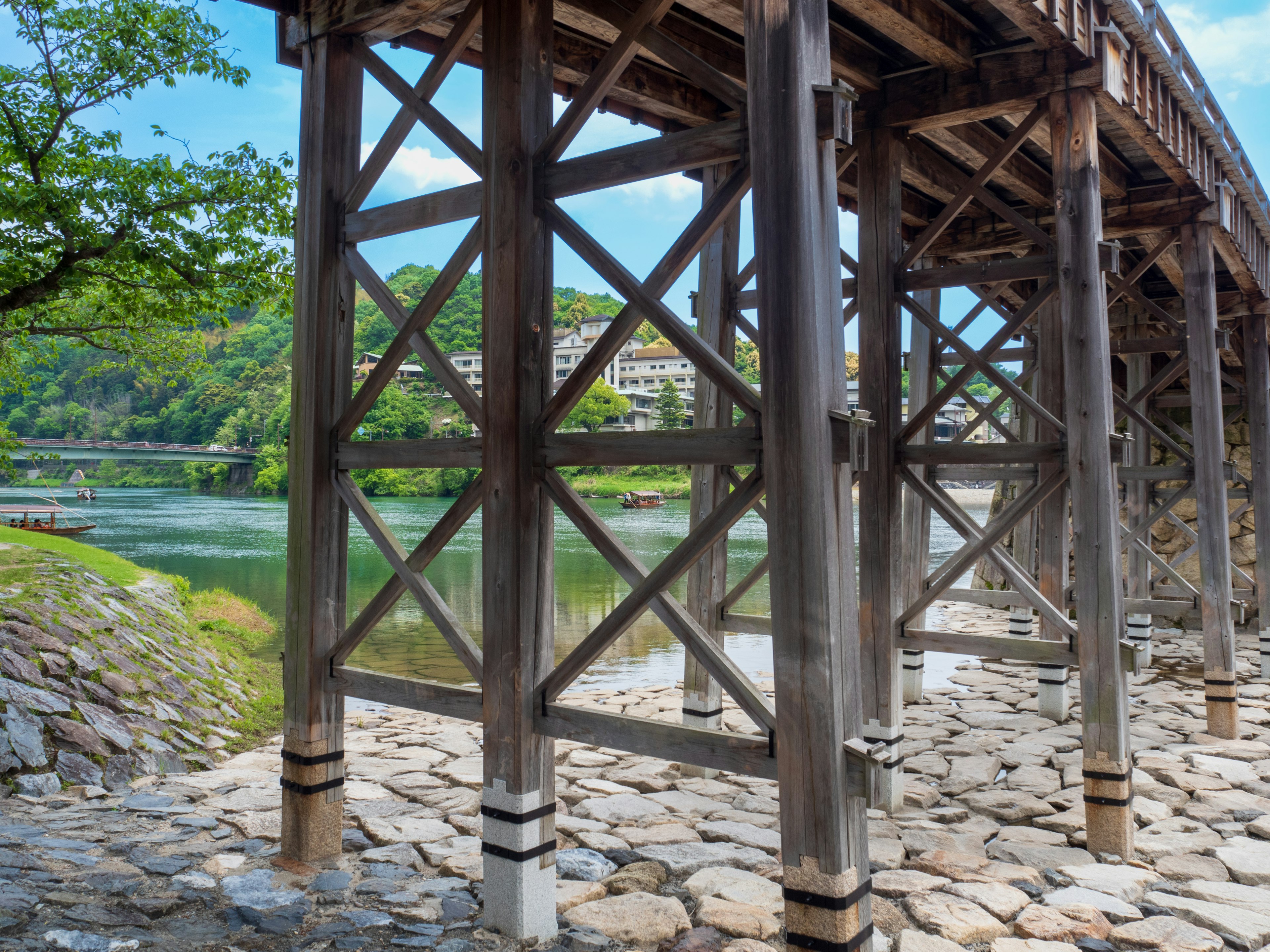 Supports en bois d'un pont au-dessus d'une rivière avec une berge en pierre