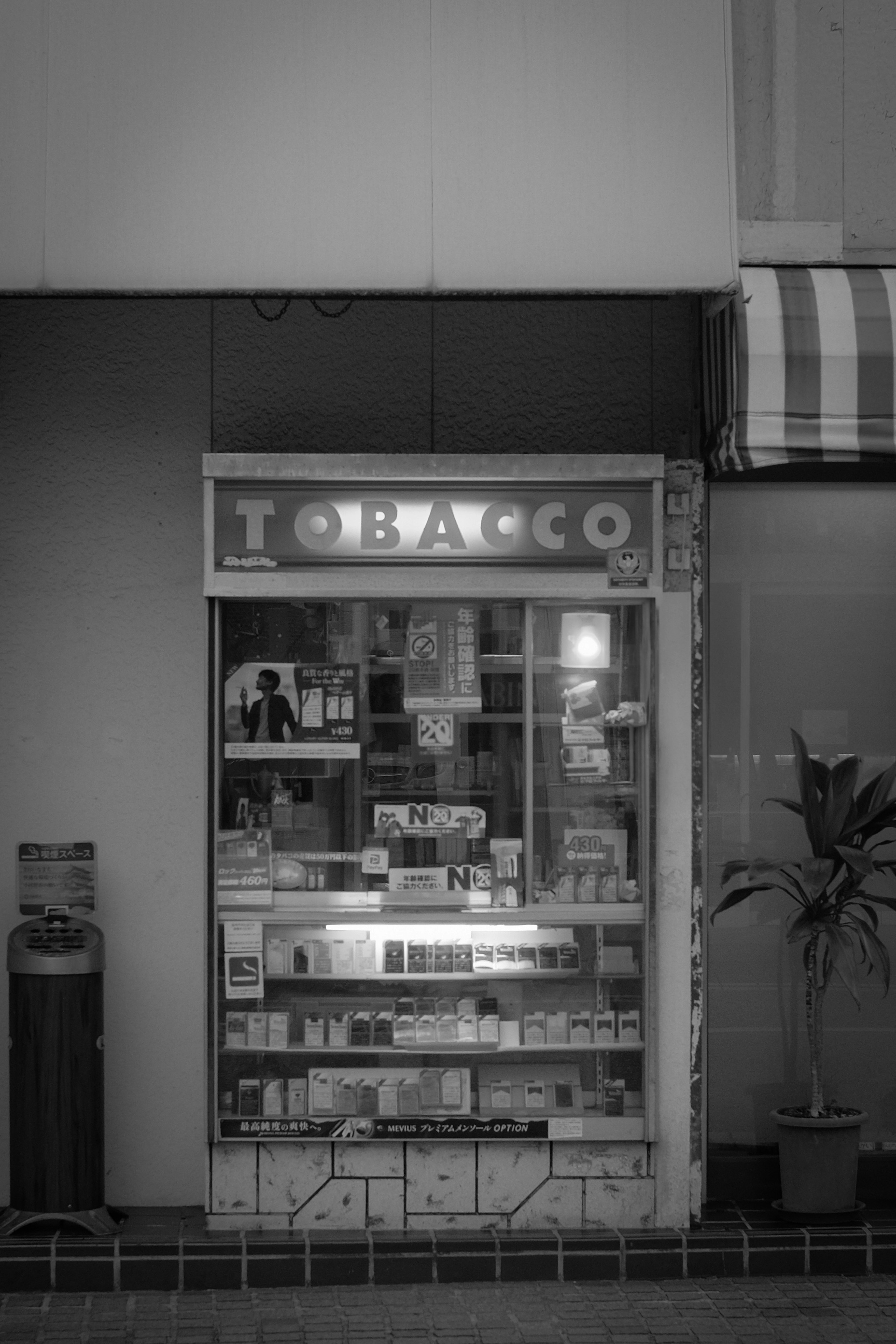 Image monochrome d'une vitrine de tabac affichant divers produits