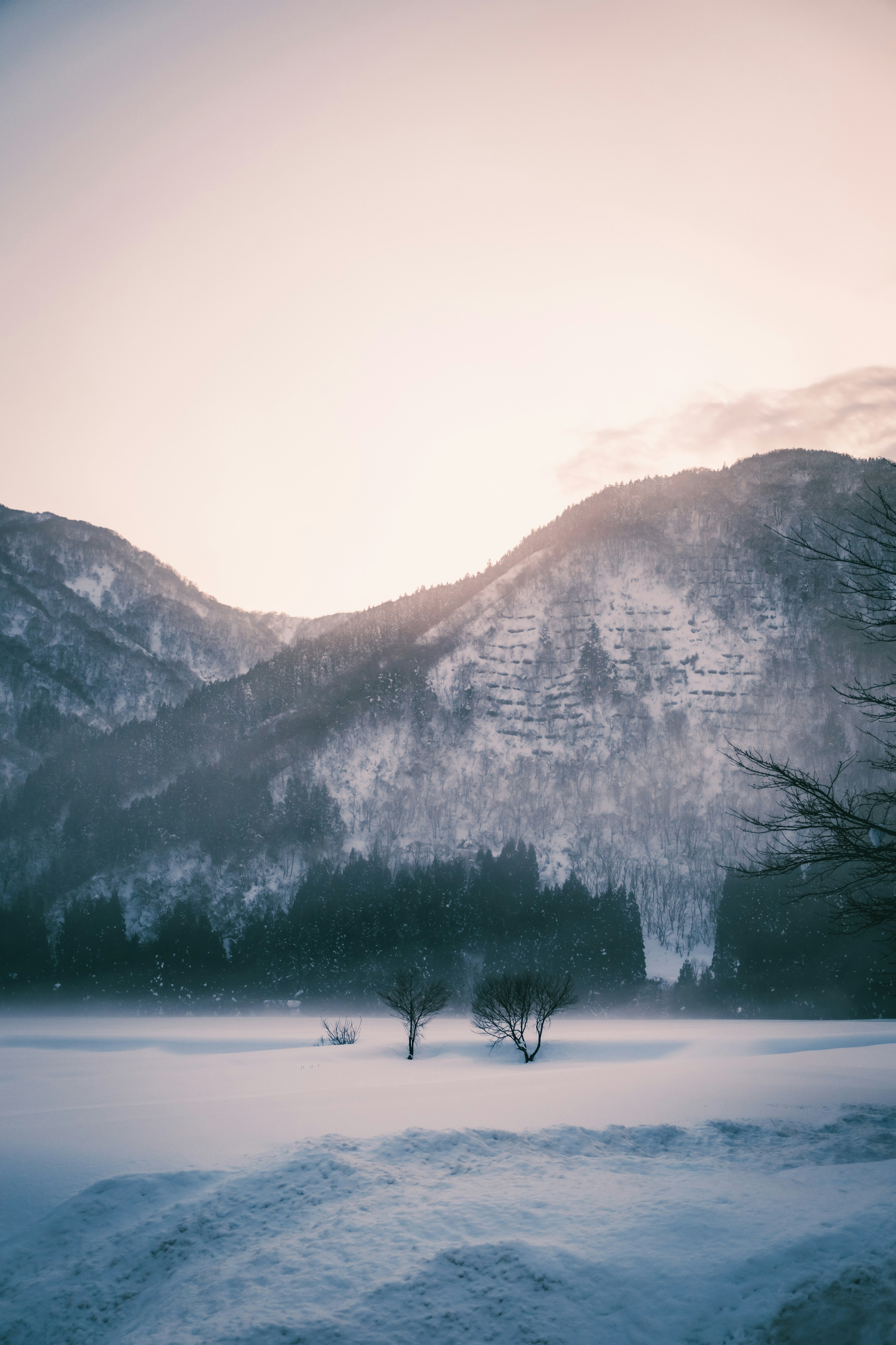 Verschneite Berge und ruhige Landschaft bei Tagesanbruch