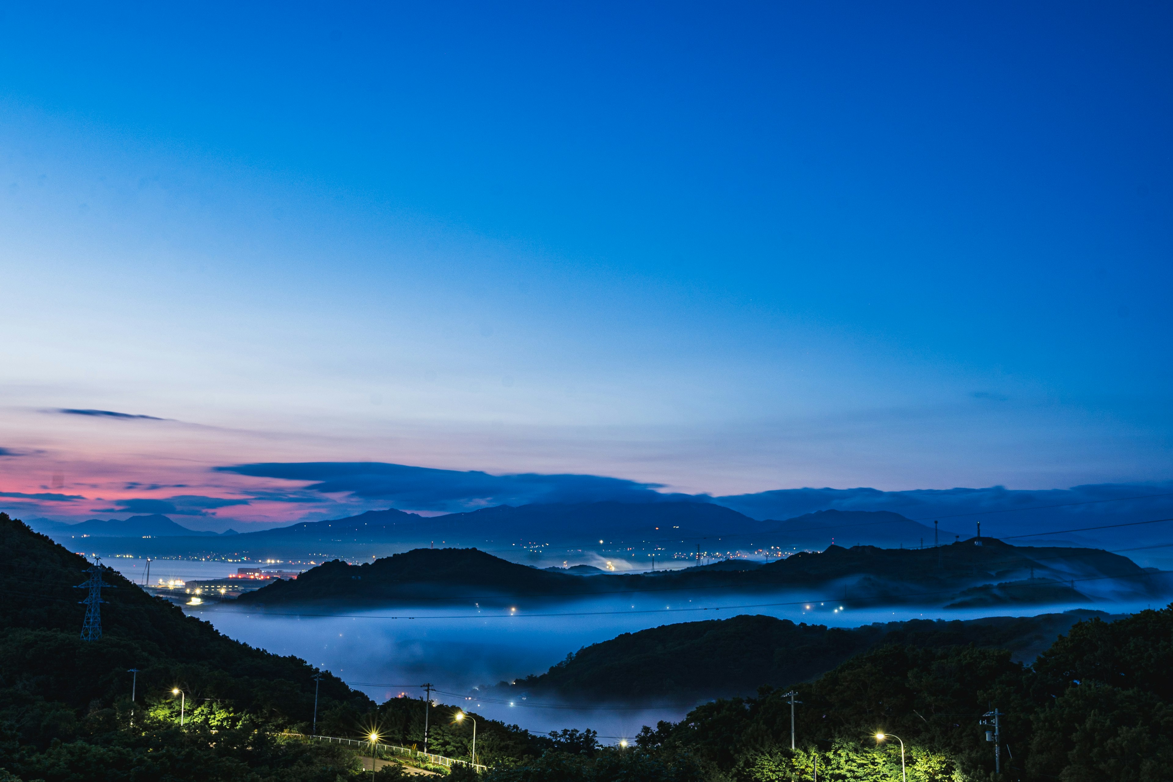 夕暮れ時の山々と霧に包まれた谷の美しい風景