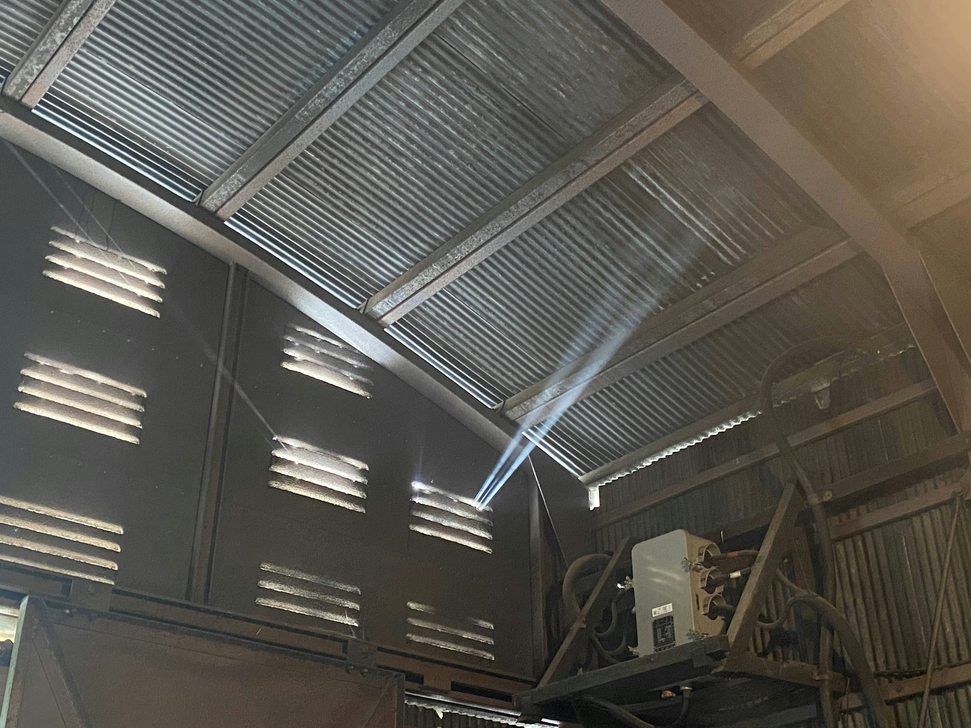 Intérieur d'une usine avec un plafond en métal et des rayons de lumière