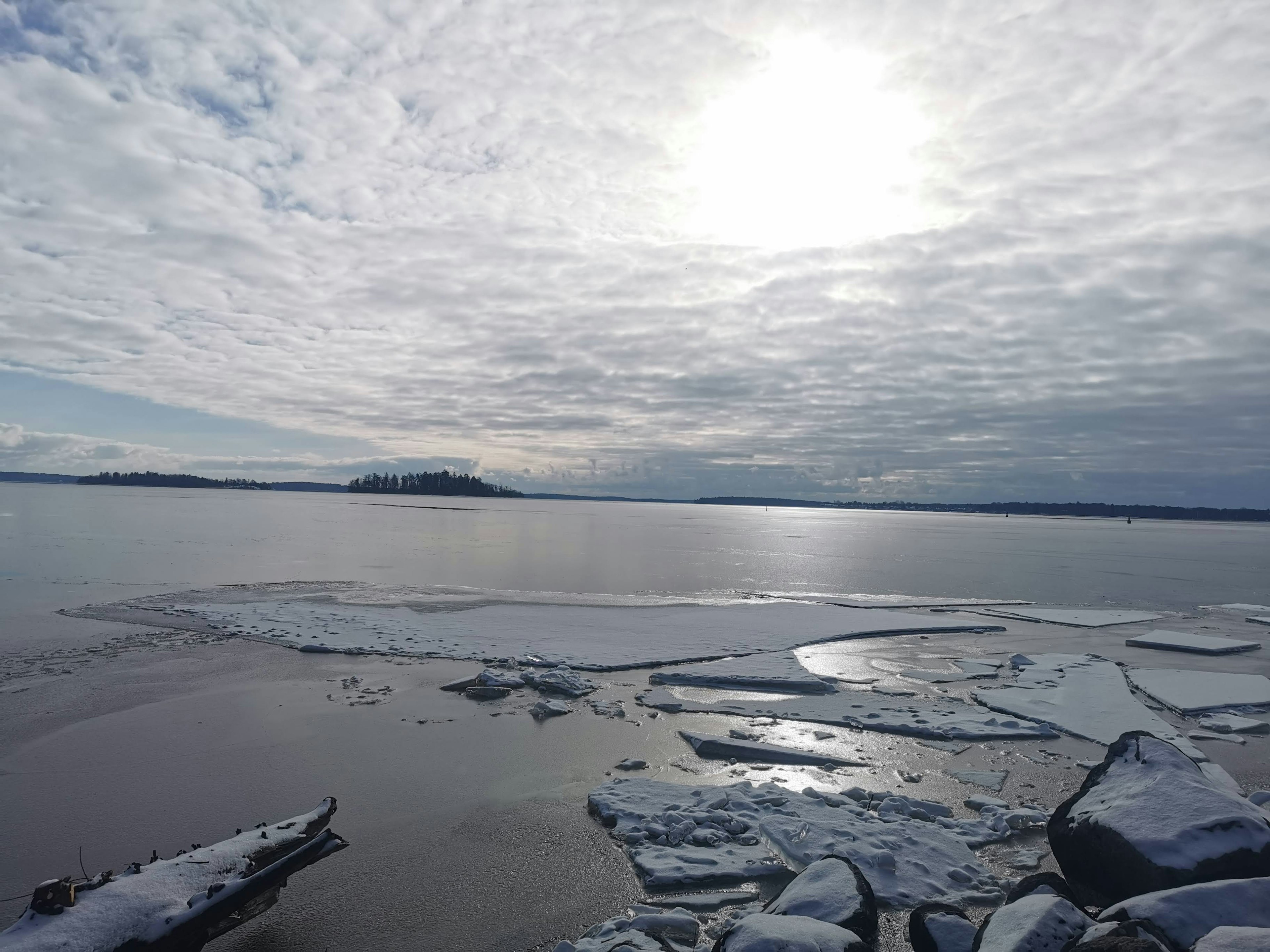 Una vista serena del lago con pezzi di ghiaccio galleggianti sotto un cielo nuvoloso