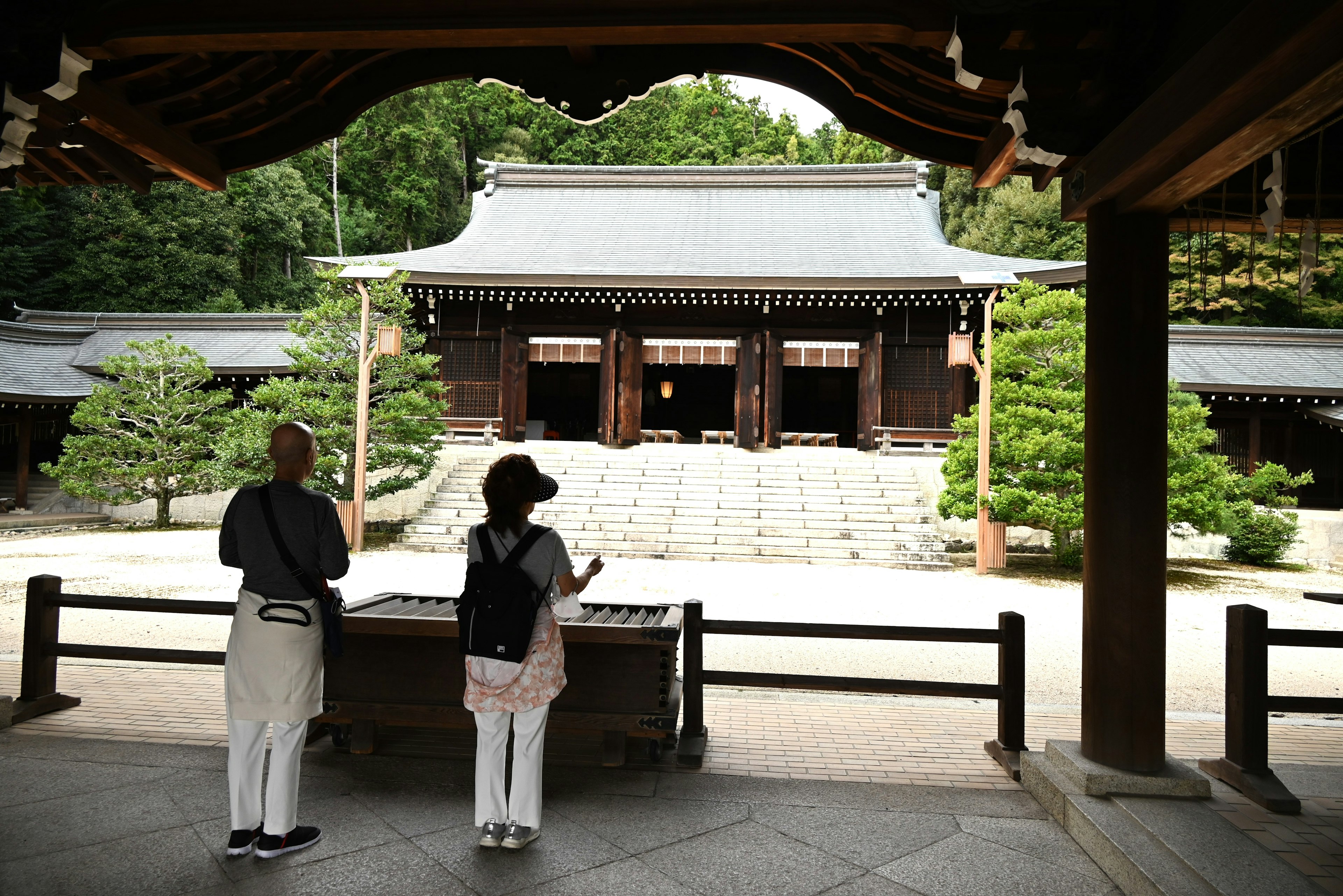 游客在宁静的神社庭院中观察传统建筑