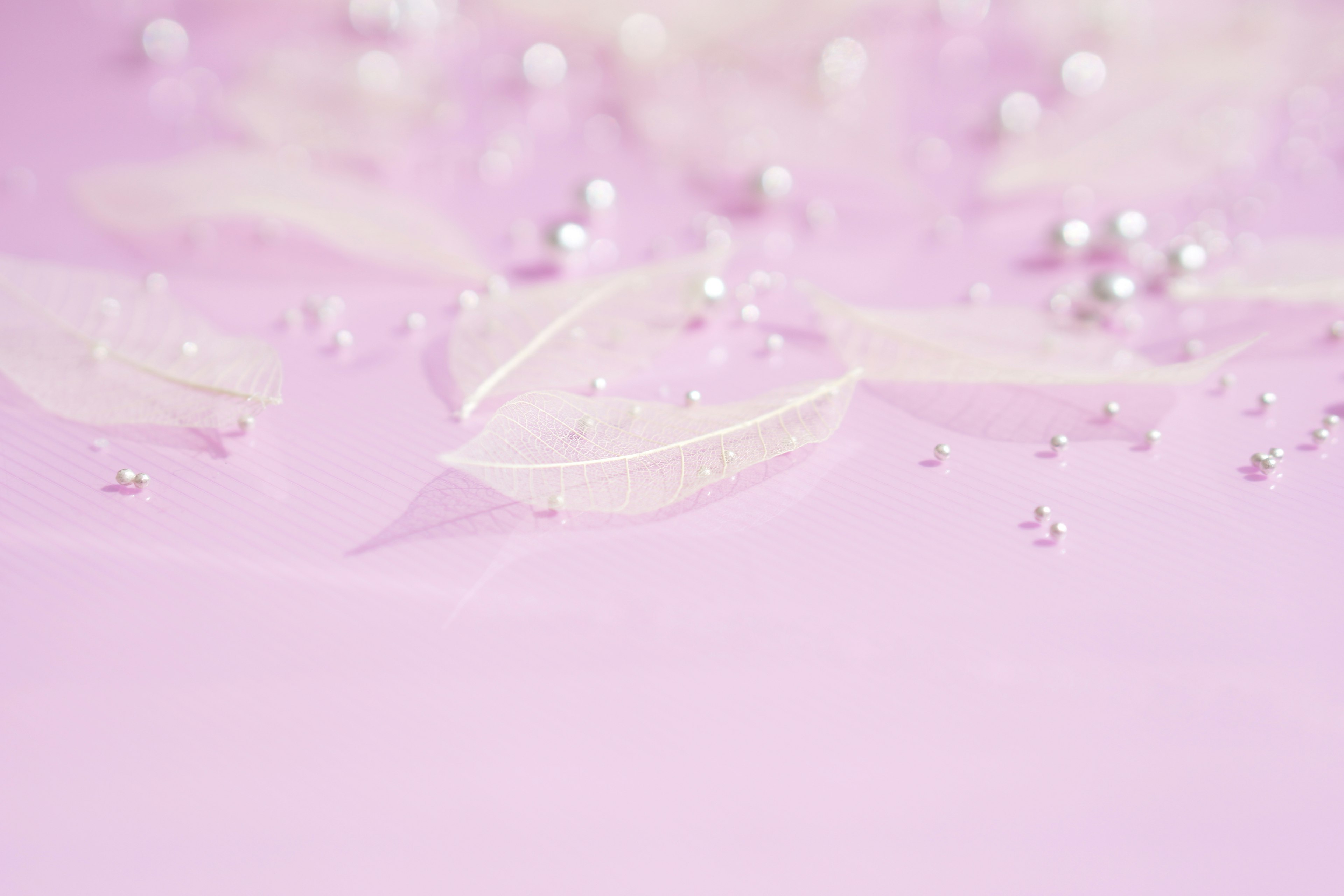 Light pink background with scattered white petals and pearls